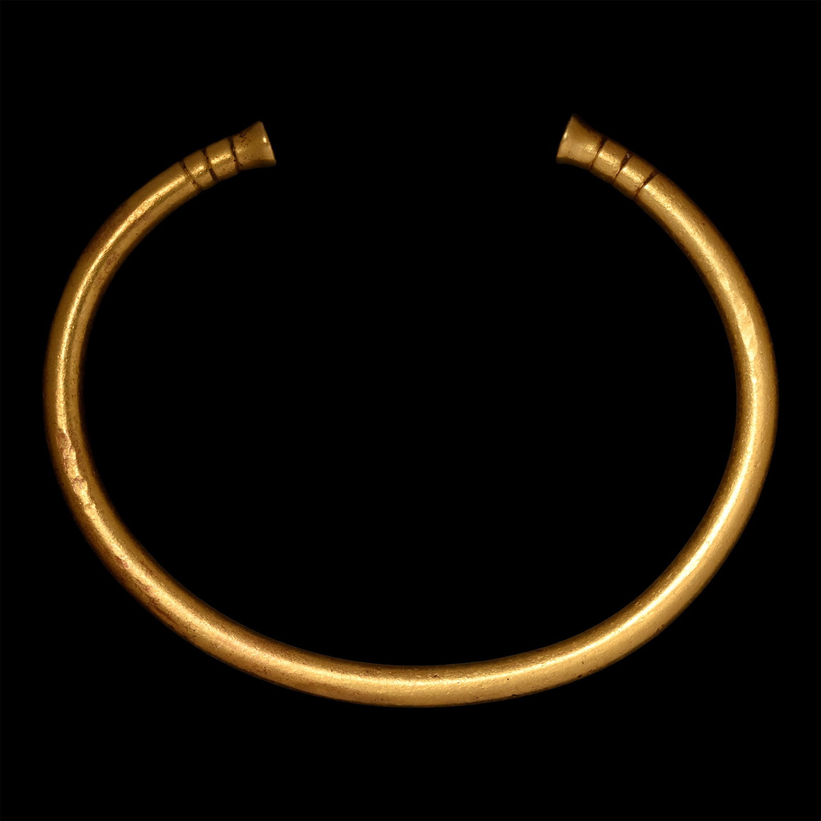 Achaemenid Solid Gold Bracelet: 5th-4th century B.C. Penannular in form and round in section with clubbed ends, three incised gussets below each finial. Cf. Schmidt, E.F., Persepolis II, Contents of the Treasury and other discoverie