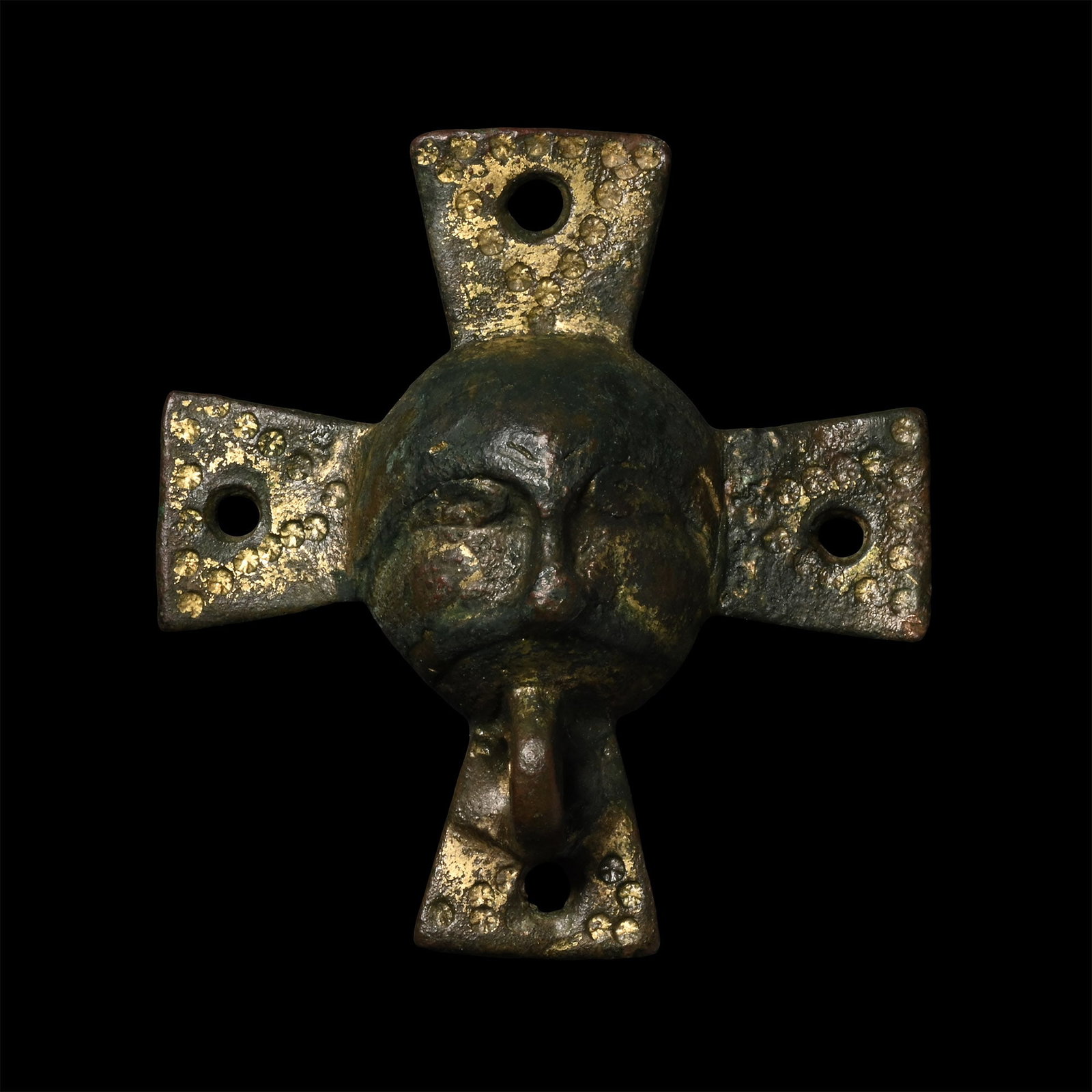 Viking Gilt Bronze Horse Harness Mount with Face: Circa 10th century A.D. Comprising a hollow central dome with four radiating trapezoidal arms, each with central piercing and bands of punched roundel decoration; dome with male face detailing, thick 