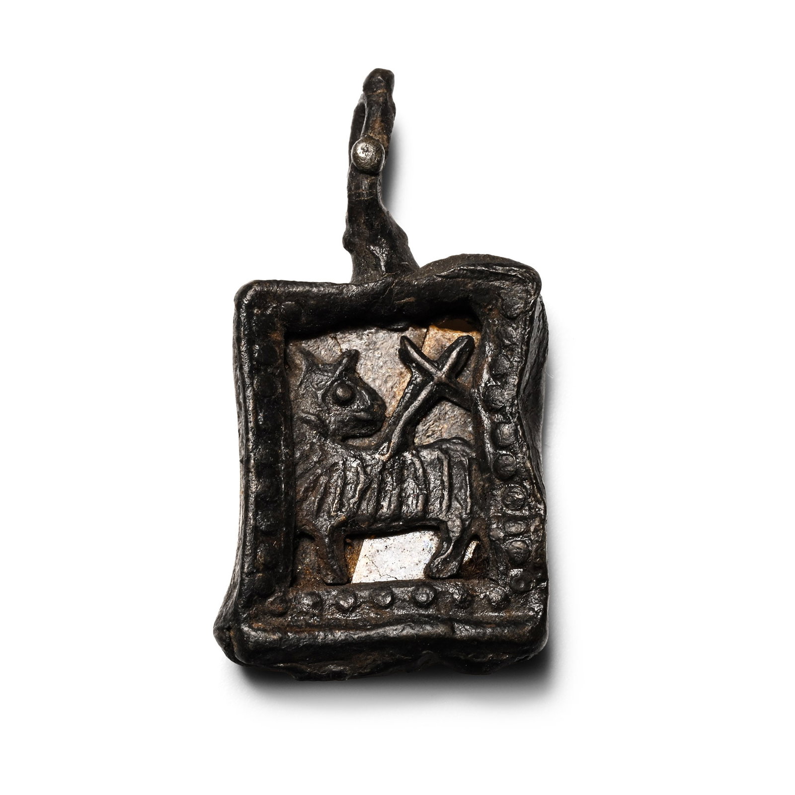 Medieval Pewter Agnus Dei Pilgrim's Badge: Circa 15th century A.D. Comprising a rectangular bifacial pelletted frame with integral loop and pellets; obverse with openwork Agnus Dei image; reverse with inset amber-coloured glass pane, a very ra