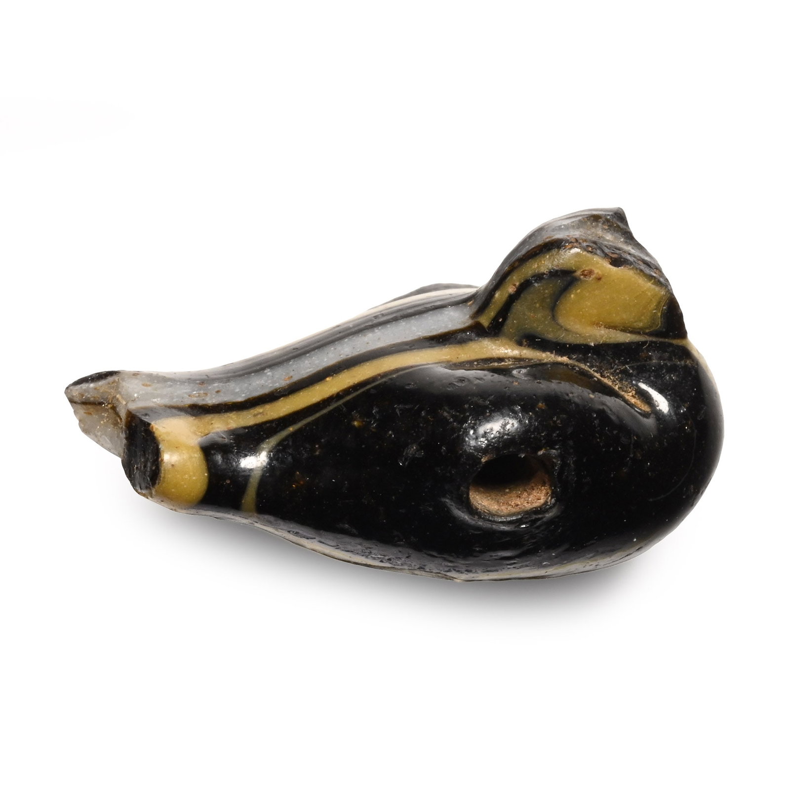 Egyptian Glass Dove Bead: New Kingdom, 18th Dynasty, circa 1550-1292 B.C. Modelled in a resting position in black glass with yellow and white trails, transverse piercing. 2.26 grams, 21.59 mm (7/8 in.). [No Reserve] From the p