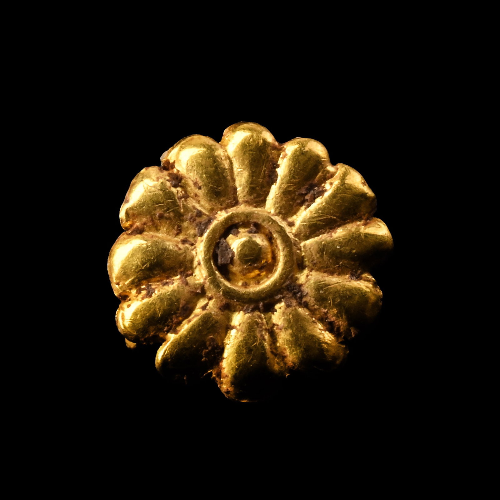 Greek Gold Floral Mount: 4th-2nd century B.C. Repoussé mount of a twelve-petalled flower, two loops on the underside. 0.24 grams, 8.25 mm (1/4 in.). [No Reserve] From the private collection of a European gentleman (1942-2024