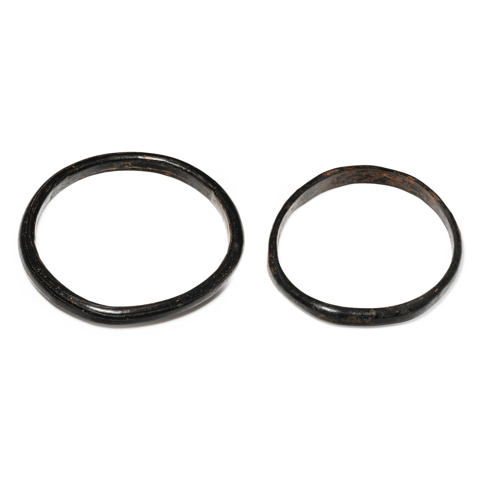 Roman Brown-Black Glass Bangle Pair: 1st-4th century A.D. Each plano-convex in section in chestnut-tinted glass. Cf. Kunstmuseum Luzern, 3000 Jahre Glaskunst, Luzern, 1981, p.103, B, for similar. 44 grams total, 80-87 mm (3 1/8 - 3 3/8 i