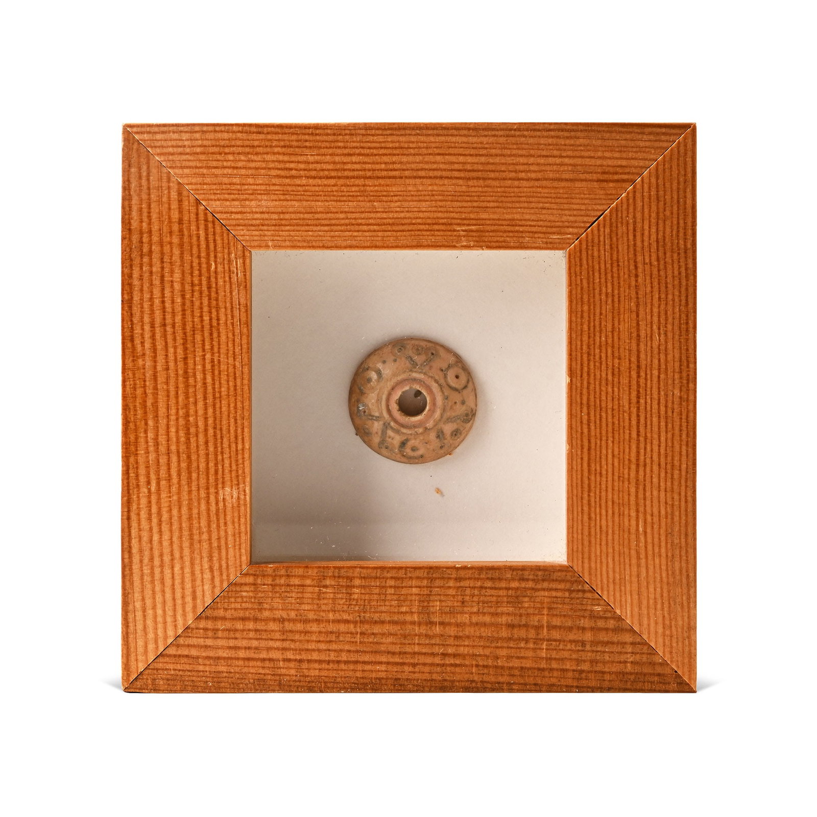 Framed Roman Decorated Stone Spindle Whorl: Circa 200 A.D. Domed body with ring-and-dot and linear decoration; set in a glazed wooden frame. 117 graams total, 93 x 93 mm including frame (3 5/8 x 3 5/8 in.). [No Reserve] Acquired from Ancient Ar