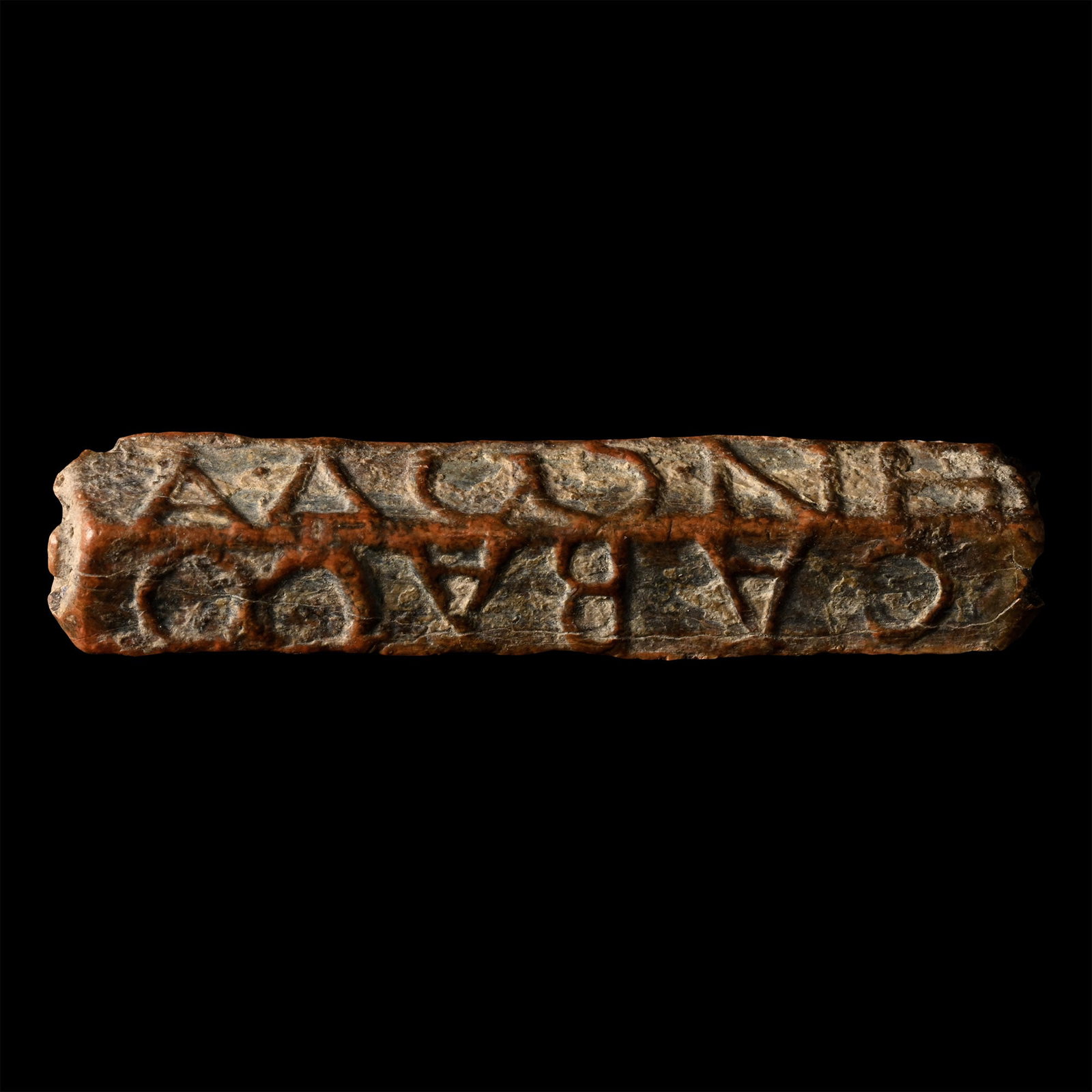 Roman Inscribed Magical Bead: 1st century A.D. Tubular bead, square in section with longitudinal piercing; reserved text to each face: (1) X?·?X (2) EIA? (3) CABAOO (4) A??NH. 6.29 grams, 33 mm (1 1/4 in.). From the London collec