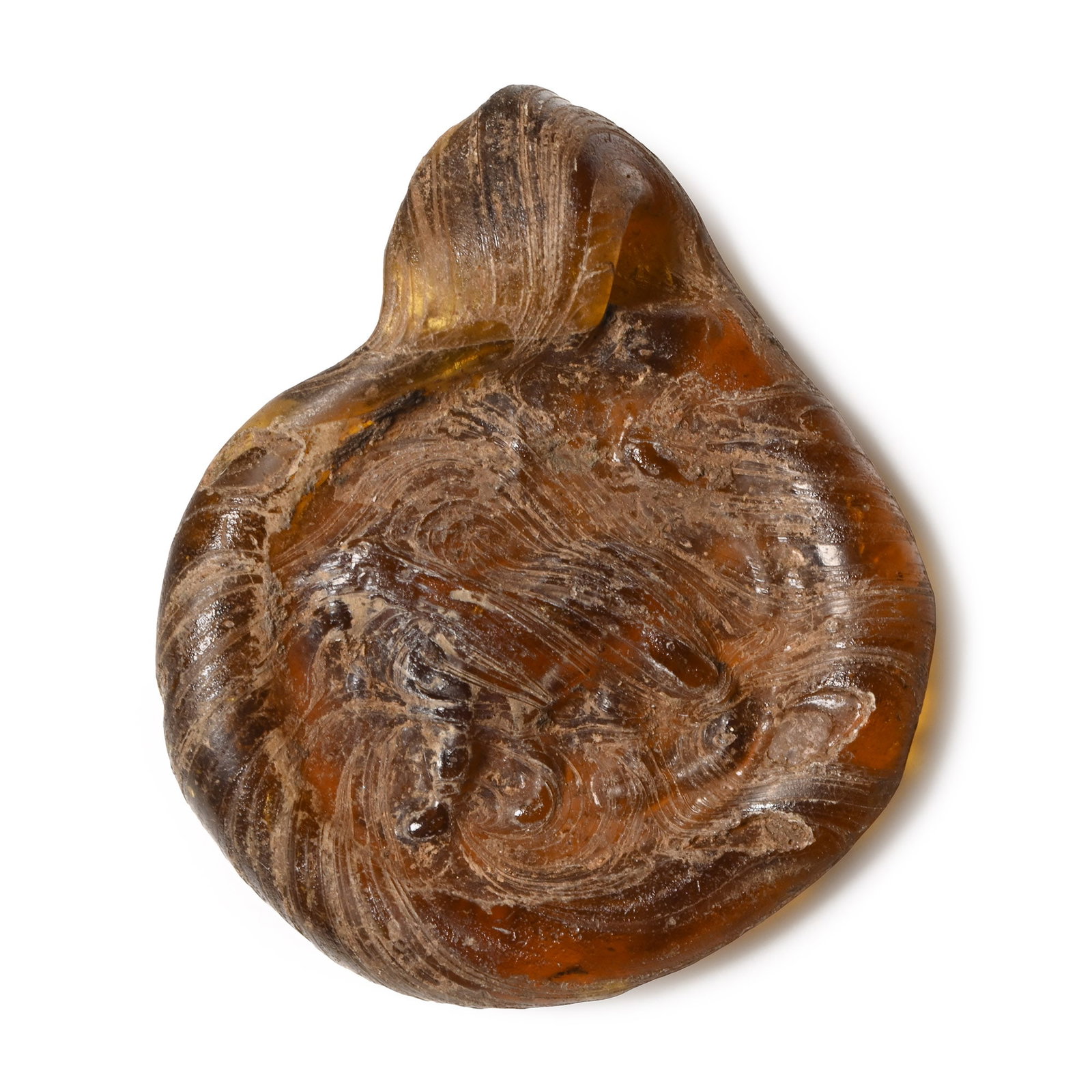 Roman Glass Pendant with Lion: 2nd-3rd century A.D. An amber-coloured discoid pendant with an impressed image of an advancing lion facing left. 2.27 grams, 24.44 mm (1 in.). [No Reserve] From the private collection of a European ge