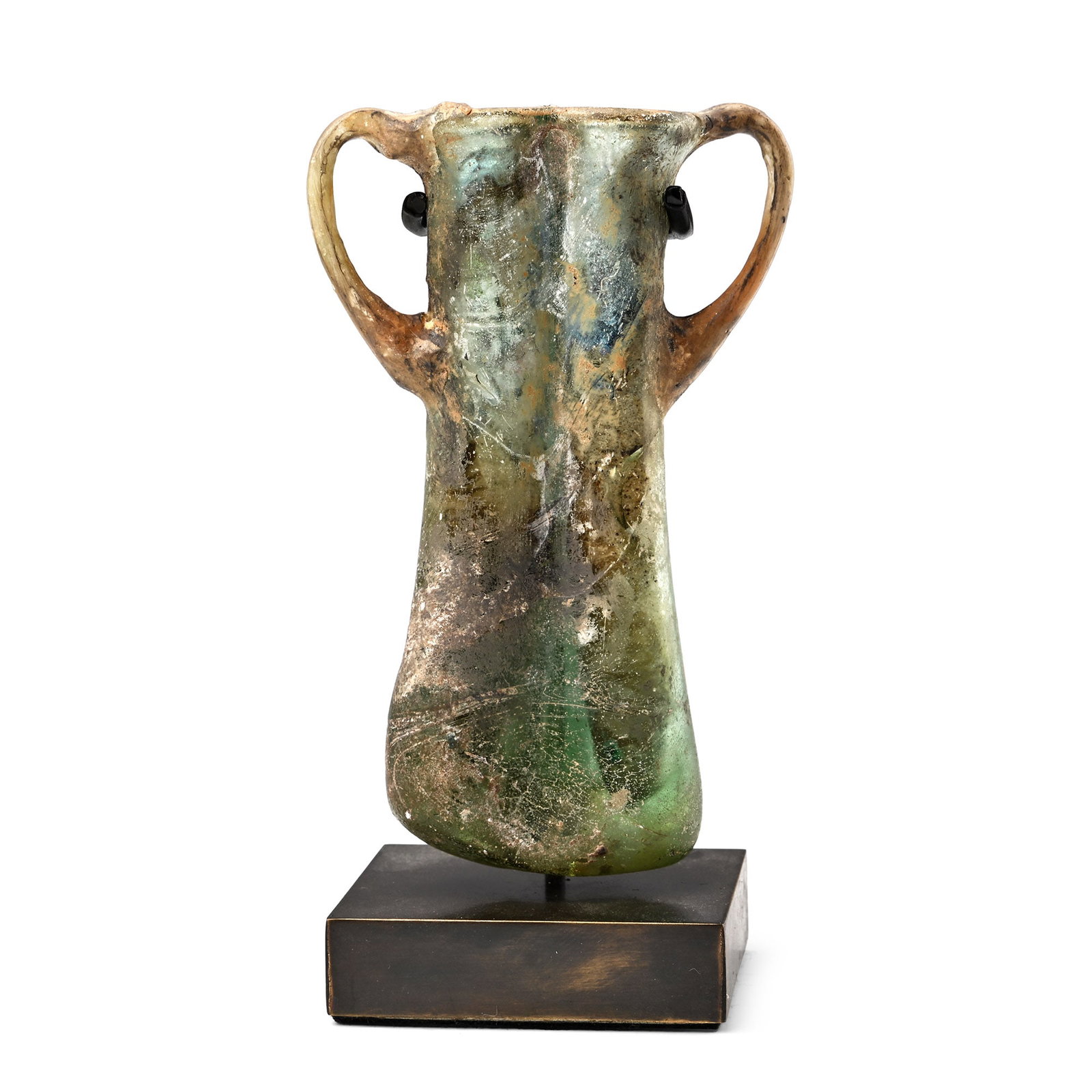 Roman Glass Double Balsamarium: Circa 4th century A.D. Formed as a pair of conjoined tubes with slightly flared tops and thickened rims; applied handles at the shoulders joined to the rim; glass with areas of iridescence; mounted on