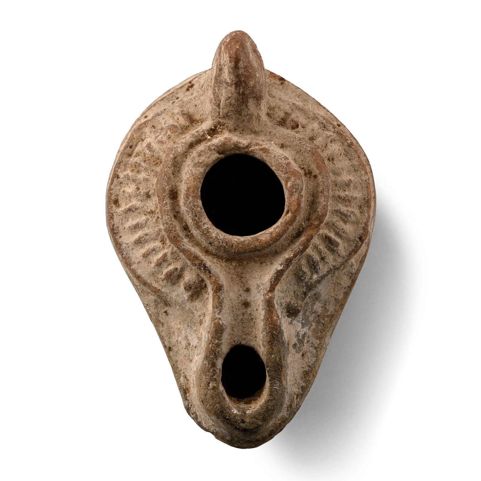 Byzantine Terracotta Oil Lamp: 7th century A.D. Slipper-shaped in plan with spike handle, raised rim to the filler hole, broad shoulder with raised radiating bars, stub nozzle, low basal ring, with inked inscription to verso which 