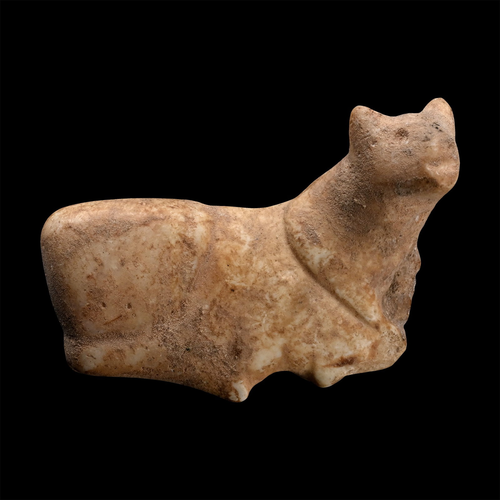 Western Asiatic Stone Bovine Amulet: 3rd-2nd millennium B.C. Modelled in the round, resting and with its head turned to the side, pierced through the body. 15 grams, 40.3 mm (1 5/8 in.). [No Reserve] From the private collection of a Euro