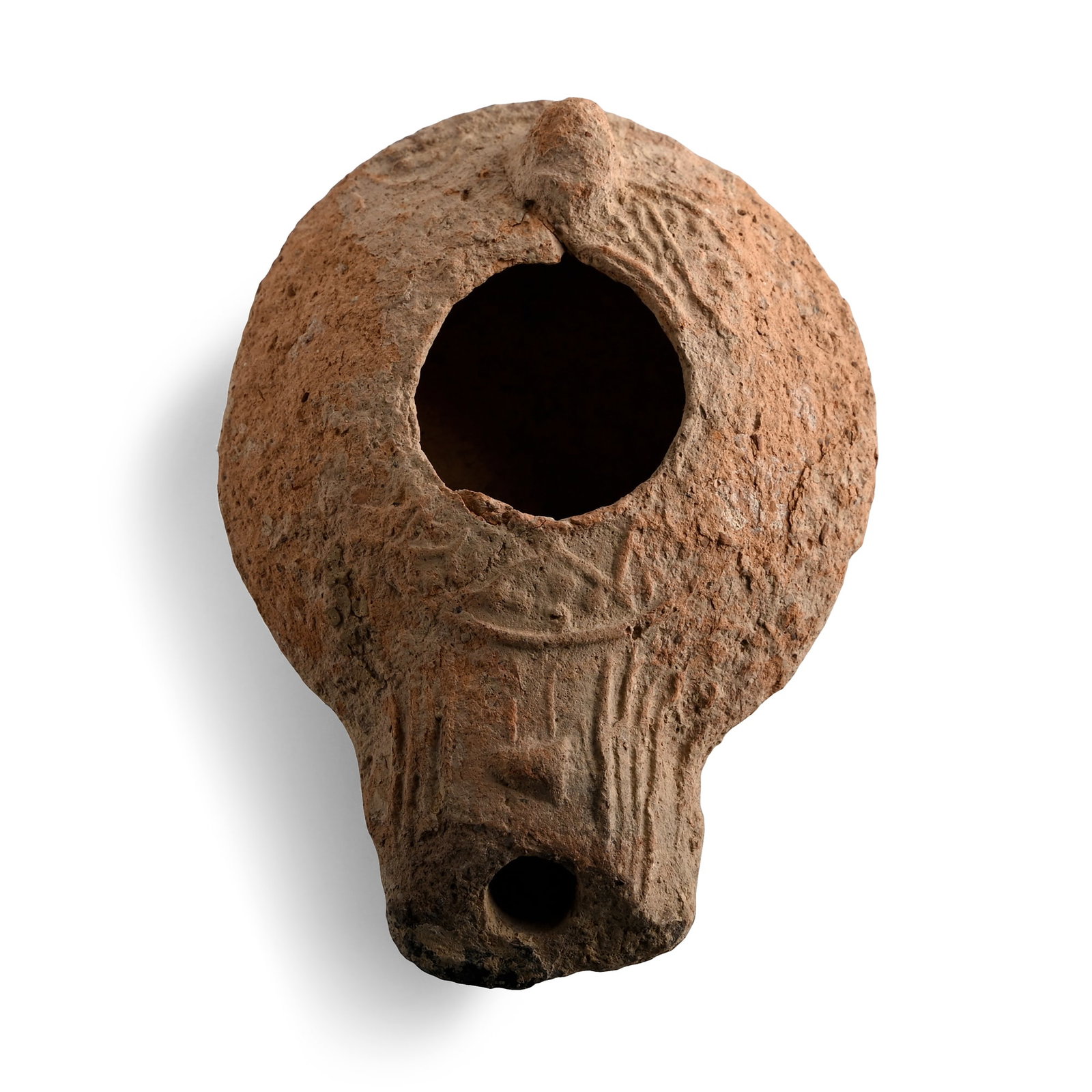 Judaean Terracotta Slipper Oil Lamp: Circa 1st century B.C.-2nd century A.D. Discoid body with broad stub nozzle, lug handle, low-relief running tendrils to the shoulder. 51 grams, 91 mm (3 5/8 in.). [No Reserve] From a collection of lam
