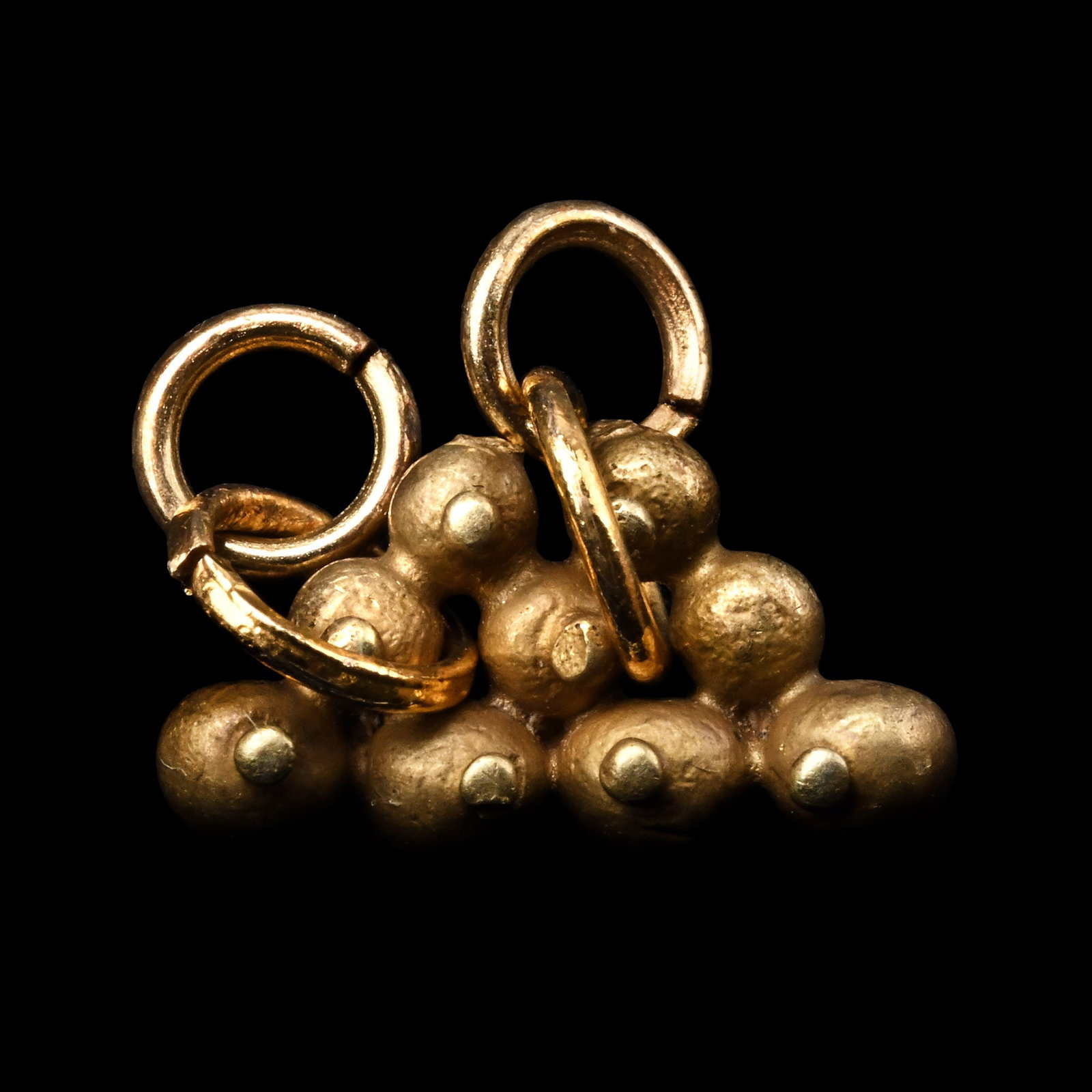 Western Asiatic Gold Pyramid Pendant: 1st millennium B.C.-1st millennium A.D. Composed of hollow-form spheres arranged in rows with applied granules and later gold-coloured loops for suspension. 1.43 grams, 16 mm (5/8 in.). [No Reserve] E