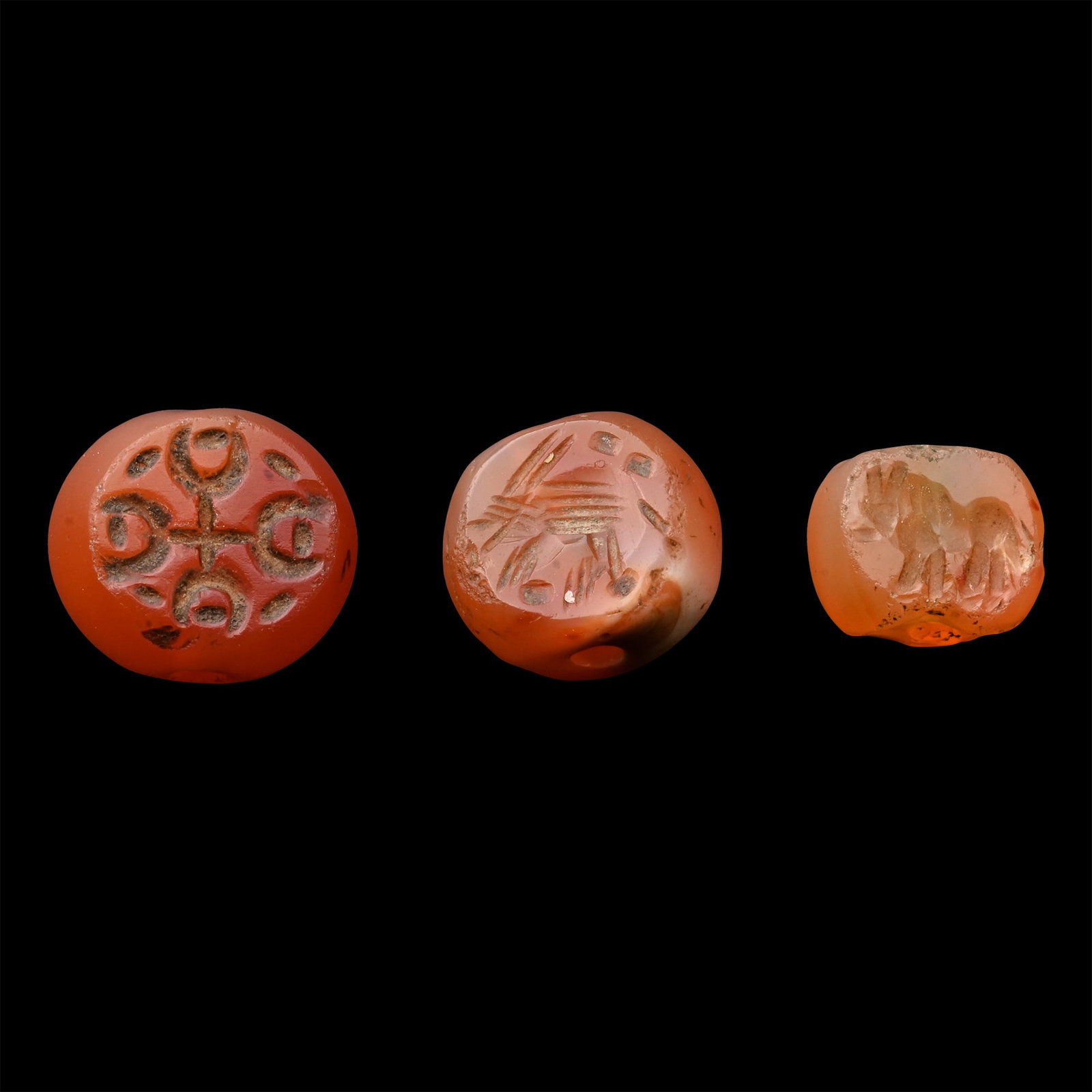 Sasanian Carnelian Stamp Seal Group: Circa 3rd-7th century A.D. Comprising: standing beast; geometric cruciform motif; standing ibex. 3.41 grams total, 8.82-11.31 mm (1/4 - 1/2 in.). [3, No Reserve] From the private collection of a Europ