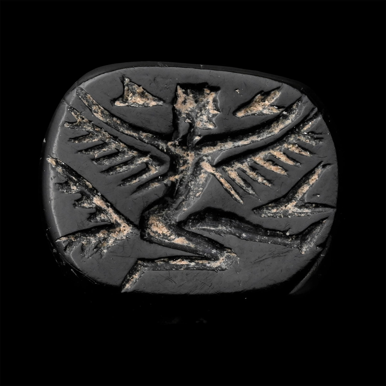 Achaemenid Black Stone Bead with Winged Goddess: Circa 5th century B.C. With incuse figure kneeling with outstretched wings. 2.80 grams, 18.30 mm (3/4 in.). [No Reserve] From the private collection of a European gentleman (1942-2024), formed since t