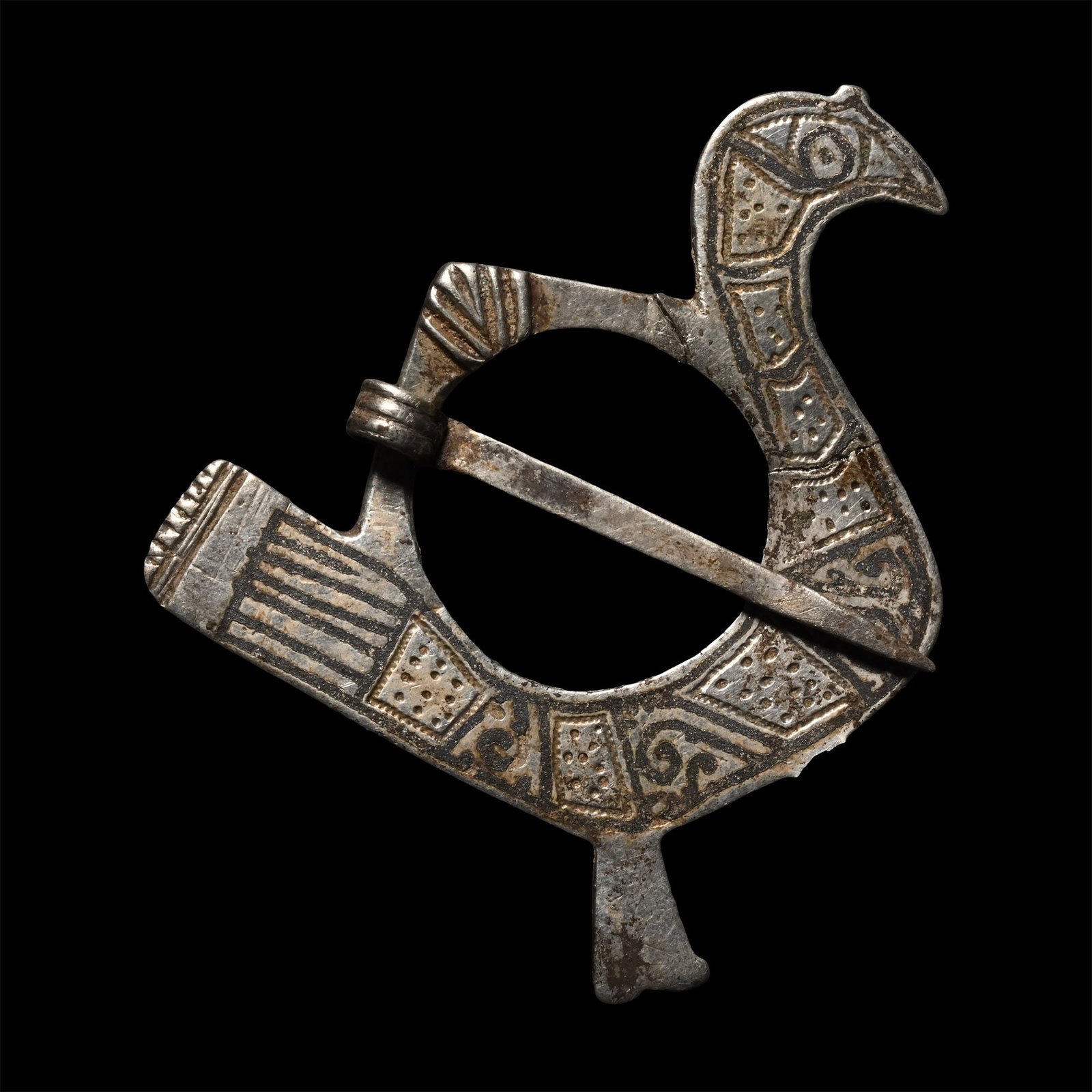 Sasanian Silver Annular Bird Brooch: 6th-7th century A.D. Formed as a stylised bird with a curving beak and long tail, an openwork wing forming the loop for the brooch, the body decorated with pellets, scrolls and linear motifs. 5.68 gra