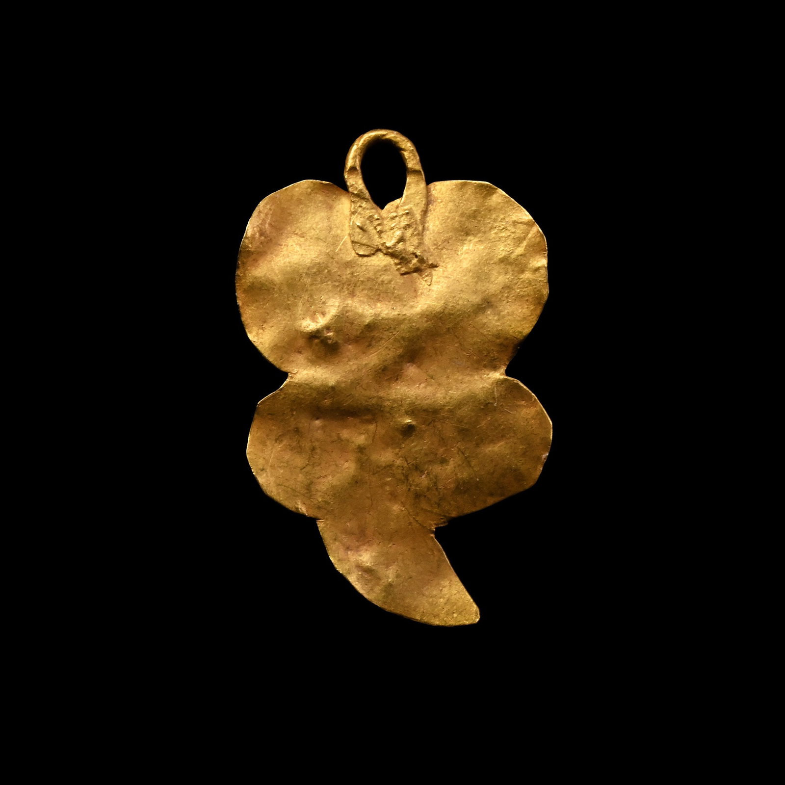 Western Asiatic Gold Pendant: 1st millennium B.C. Four-lobed body formed from sheet-gold with a comma-shaped finial, suspension loop above. 0.15 grams, 14 mm (5/8 in.). [No Reserve] Ex private British collection, formed in the 198