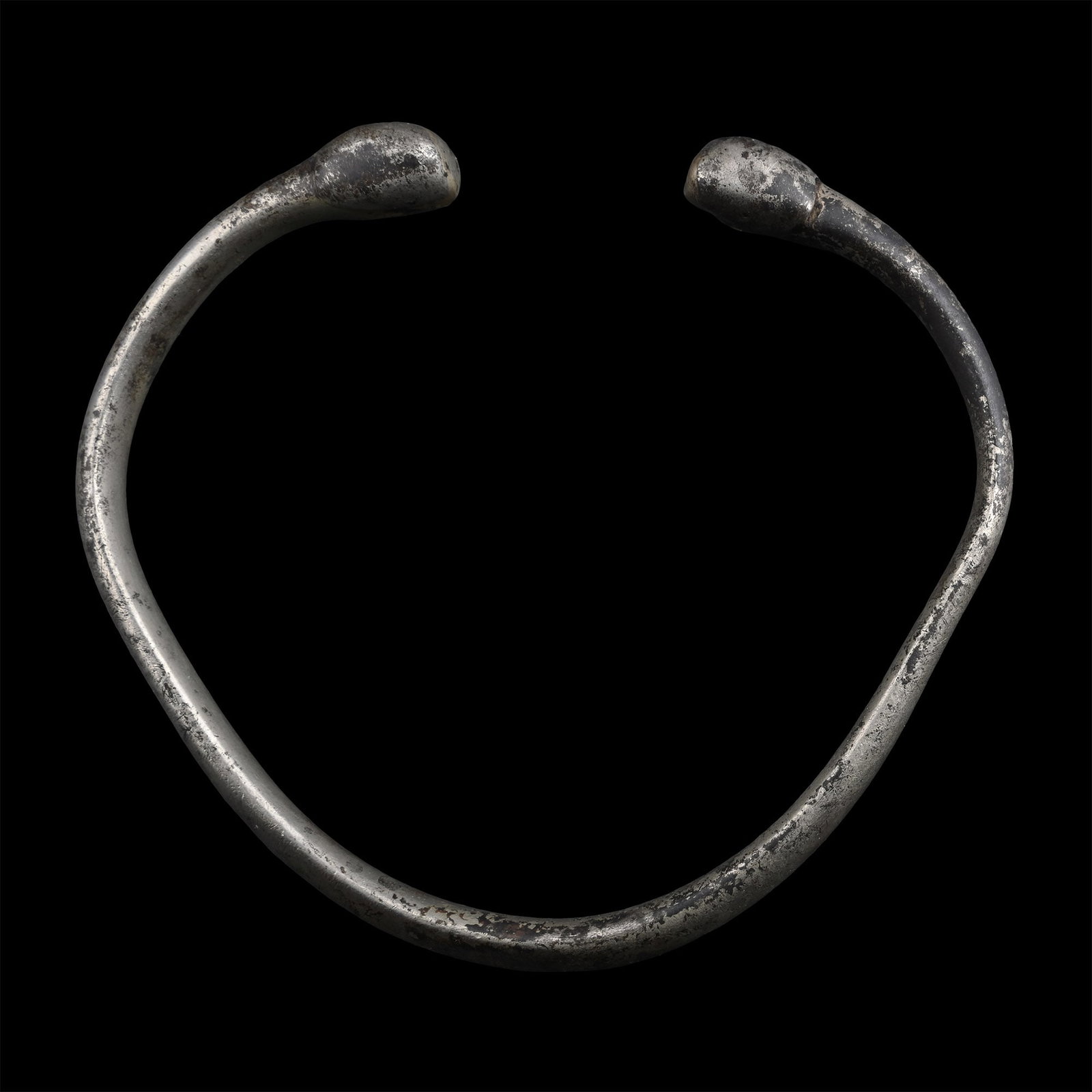 Luristan Silver Bracelet: 1st millennium B.C. Penannular type with thick D-section shank, bulb finials. 66 grams, 95 mm (3 3/4 in.). From the collection of a gentleman, acquired on the London art market in the 1990s. TimeLine 