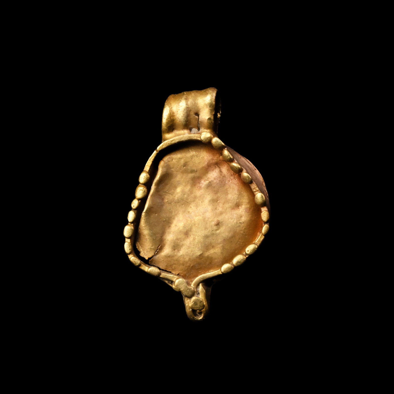 Western Asiatic Sun-Disc Gold Pendant: 1st millennium B.C. Formed as a circular disc with a granulated edge and ribbed suspension loop, applied granule at the base. 0.10 grams, 9 mm (3/8 in.). [No Reserve] Ex private British collection, fo