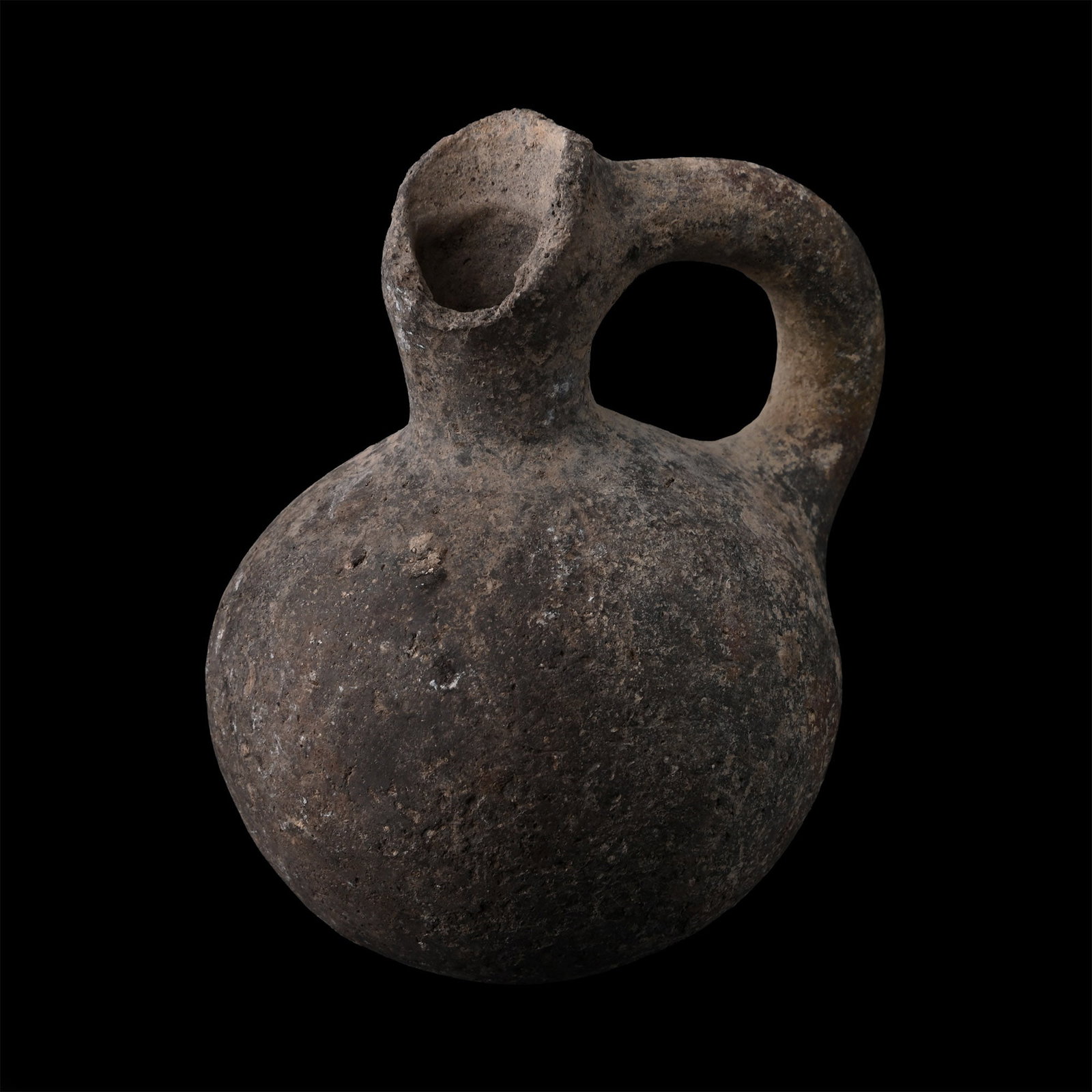 Holy Land Black-Burnished Spouted Vessel: Early Bronze Age, circa 1800-1600 B.C. Comprising a spherical body and a narrow neck with a handle at the rear. 66.6 grams, 76 mm (3 in.). [No Reserve] From the collection of a Yorkshire, UK gentleman