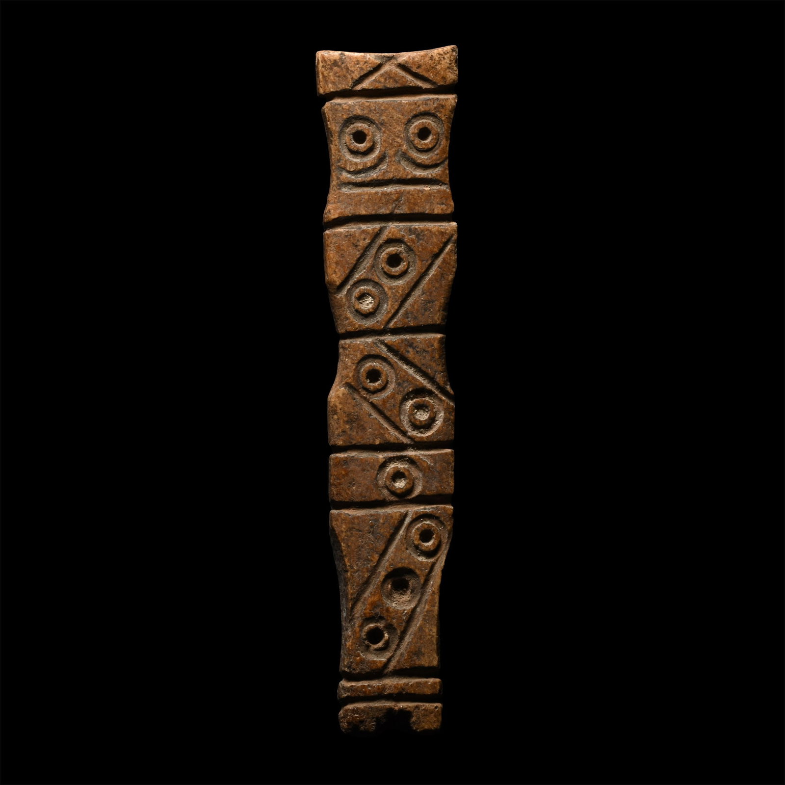 Western Asiatic Bone Idol: 2nd century B.C.-2nd century A.D. Rectangular in section with waisted profile, incised zigzag, ring-and-dot and other motifs to both faces. 7.14 grams, 74.82 mm (3 in.). [No Reserve] From the private 