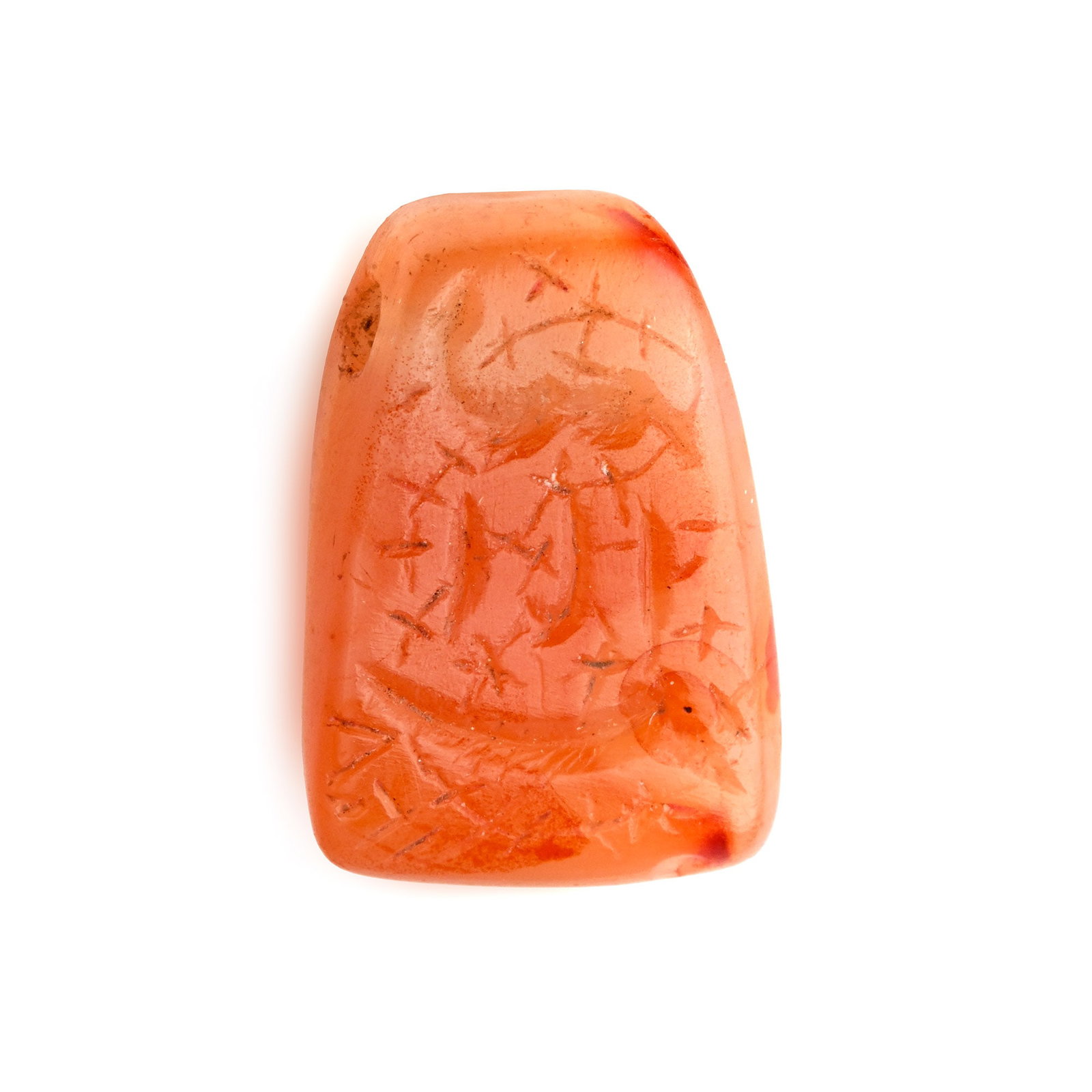 Western Asiatic Carnelian Amuletic Pendant: Late 1st millennium B.C. Tongue-shaped in profile with scrolled tendrils and three rows of large incuse characters. 3.04 grams, 19 mm (3/4 in.). [No Reserve] From the collection of a gentleman, acquir