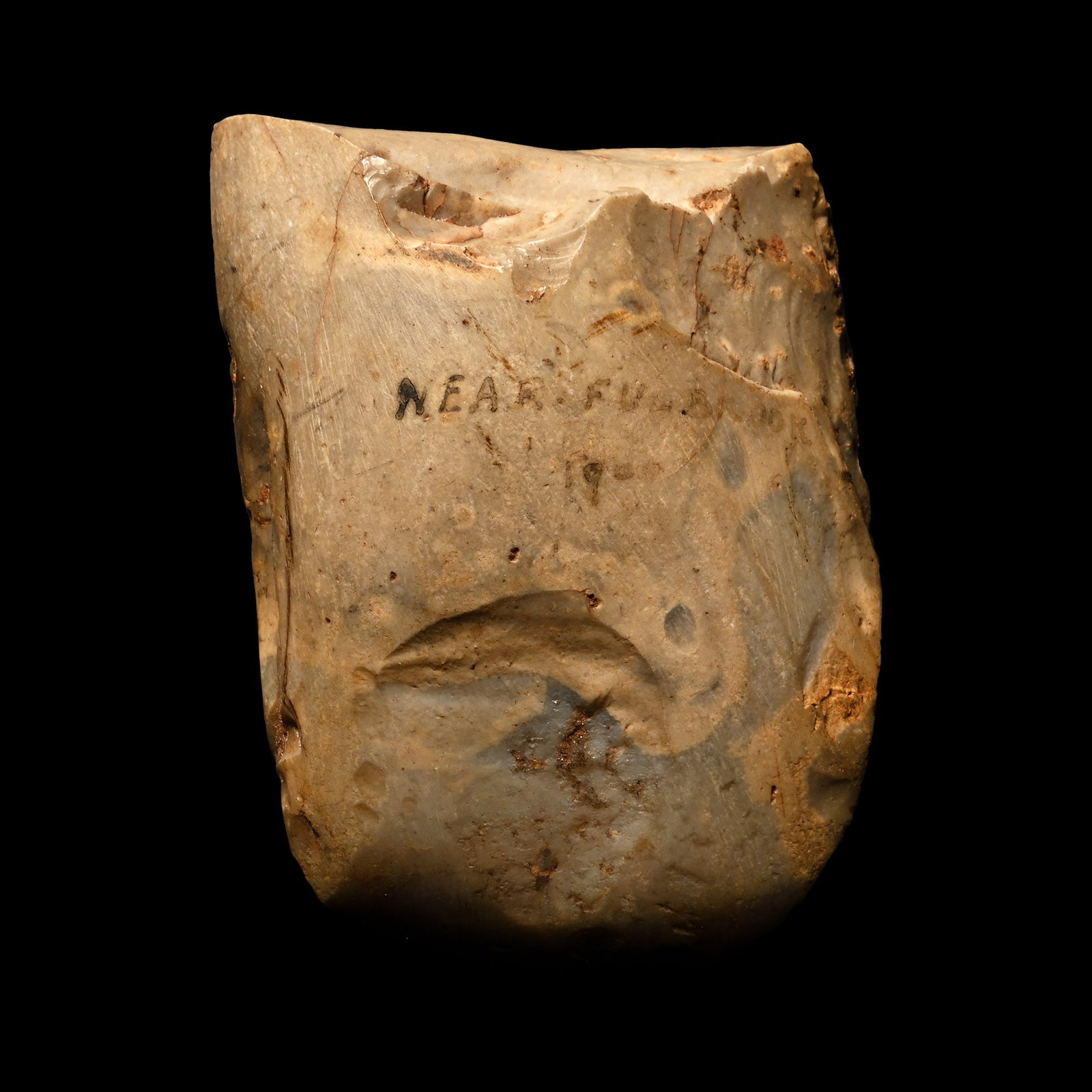 British Stone Age Polished Axe Head from Farnham: Neolithic Period, circa 6000 B.P. Lentoid in section with a rounded cutting edge; inked findspot 'Near Fulbrook 19[.]'. 208 grams, 78 mm (3 in.). [No Reserve] Found in 1901. From the collection of Cap