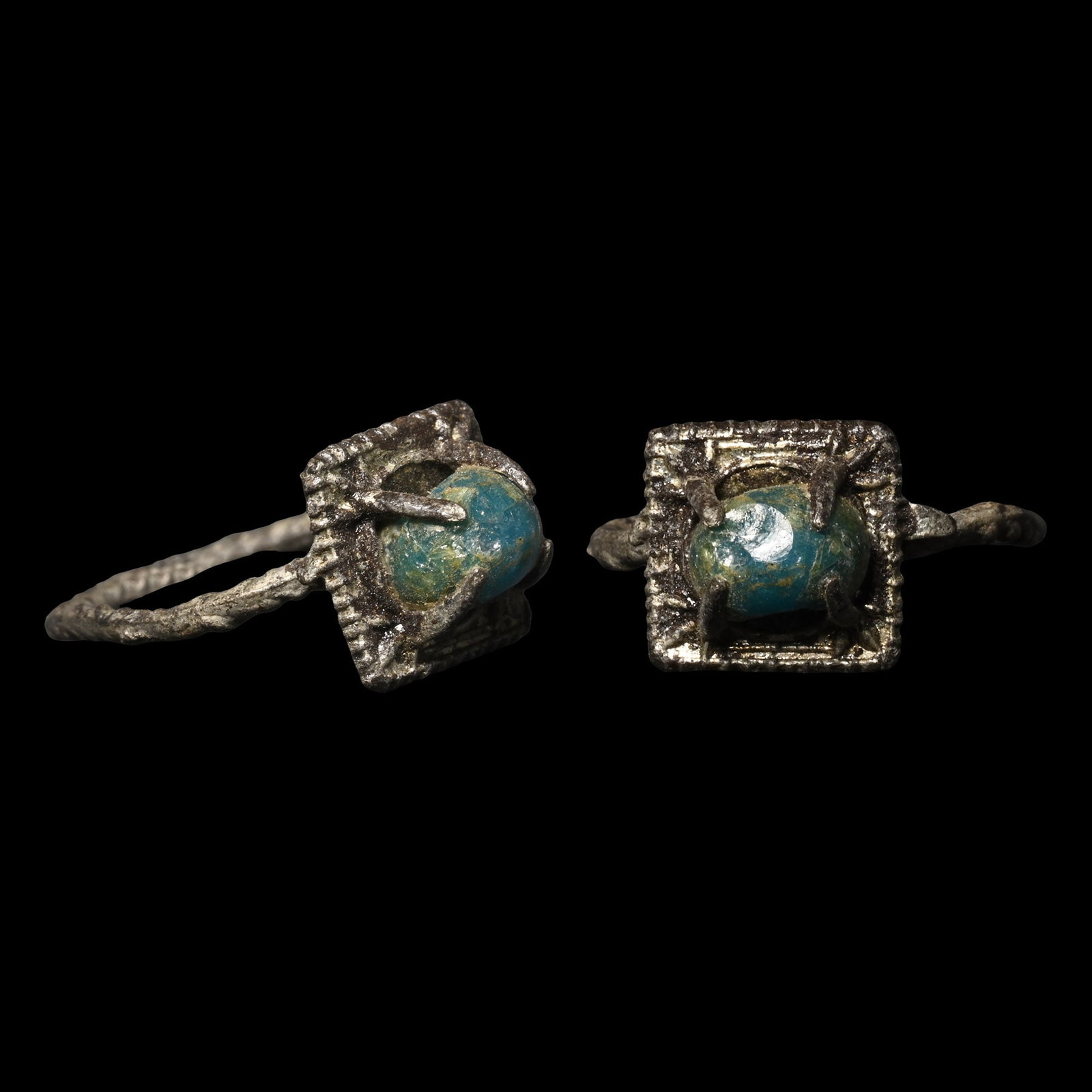 Viking Age Bronze Ring with Cabochon: Circa 9th-12th century A.D. Comprising a faux-twist hoop and square bezel with a reused glass bead cabochon in a claw setting. 1.26 grams, 22.46 mm overall, 14.05 mm internal diameter (approximate siz
