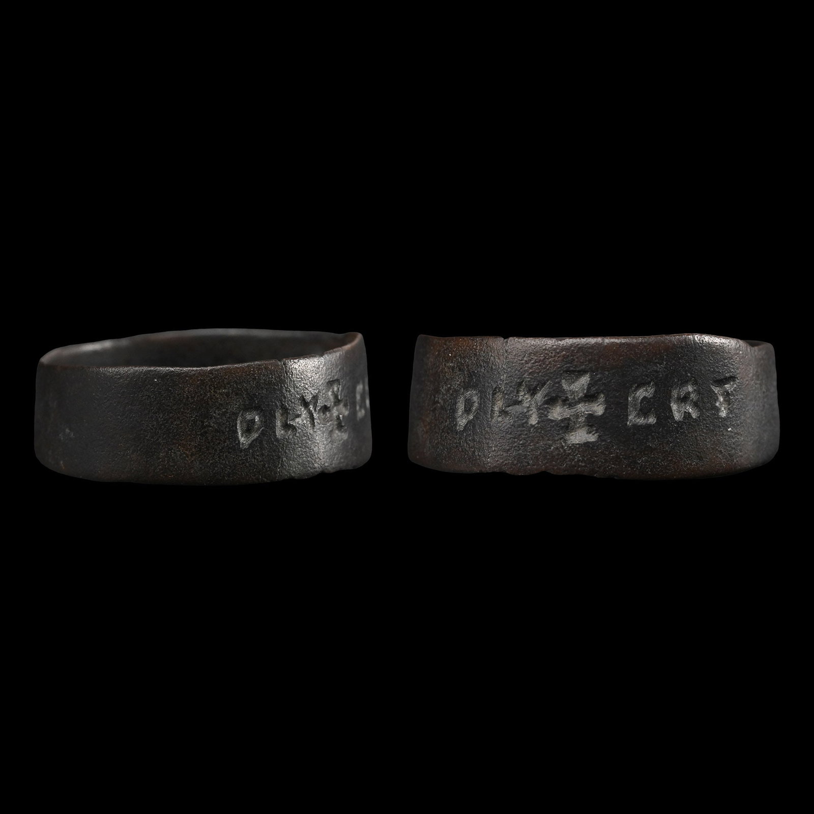 Medieval Bronze Ring with Cross and Inscription: 12th-13th century A.D. Flat-section hoop with a central cross and inscription on both sides 'PLY / CRT'. 2.42 grams, 23.35 mm overall, 21.87 mm internal diameter (approximate size British X, USA 11 1/