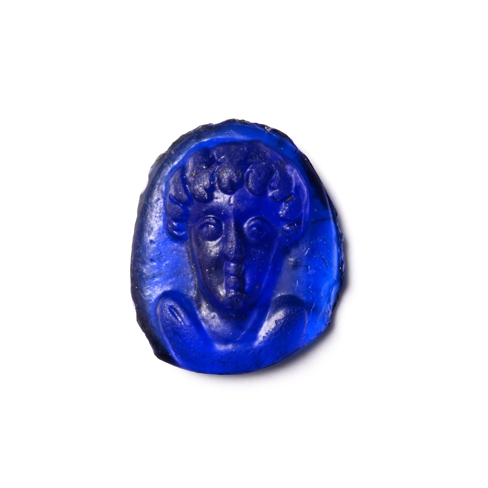 Post-Classical Blue Glass Cameo of a Man: 19th century A.D. or earlier Discoid in plan with a facing bust with tousled hair. 0.64 grams, 12 mm (1/2 in.). Private English collection, formed between the late 1970s and early 1990s. Private colle