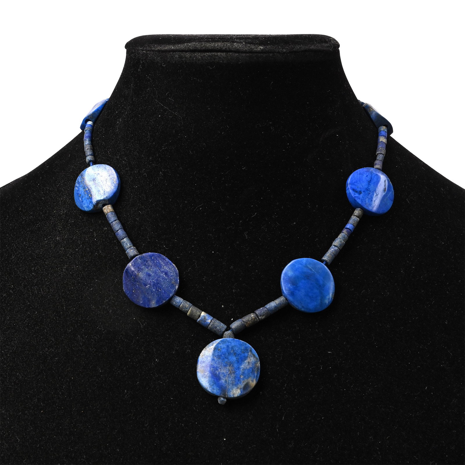 Western Asiatic Style Lapis Lazuli Bead Necklace String: 20th century A.D. Composed of large coin-shaped feature beads interspersed with cylindrical beads; restrung. 37 grams, 33 cm (13 in.). [No Reserve] Ex London, UK, art market 1990s. TimeLine Auctions f