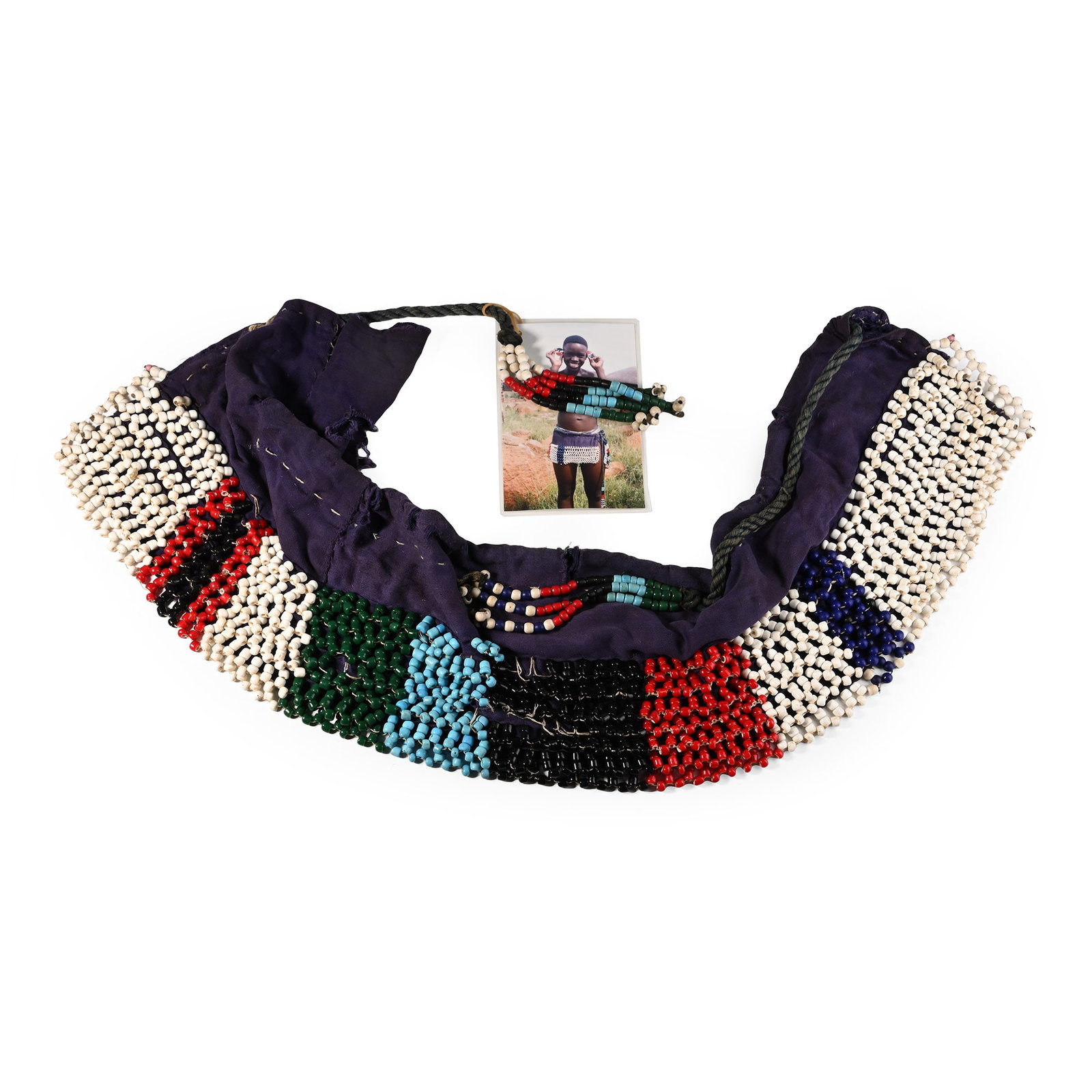 Zulu Woman's Beaded 'Itete' Marriage Apron and Photograph of a Descendant of the Owner: 20th century A.D. A fabric apron decorated with vibrant polychrome beads; some beading detached from the fabric. 988 grams total, 158 cm long (62 1/4 in.). [No Reserve] Collected October 2003 near Ile
