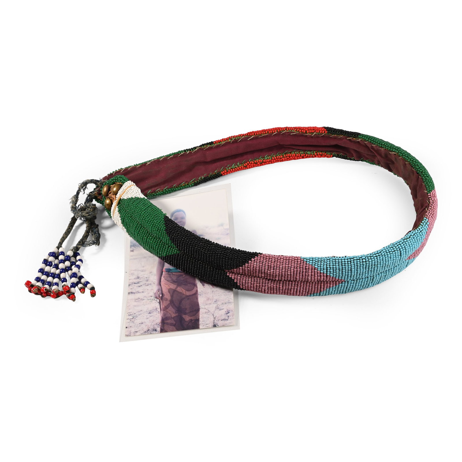 Zulu Woman's Beaded 'Ixama' Belt and Photograph of Ms Kokuthula Ncele a descendant of the Owner: 20th century A.D. Woven from Ncema grass with fabric backing, decorated with polychrome beads arranged in the 'mashunka' pattern, and with brass studs at each finial. 300 grams total, belt: 84 cm long
