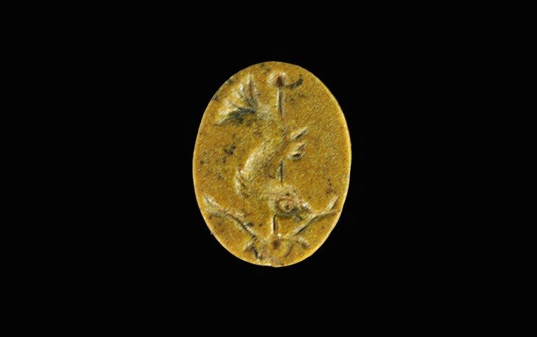 Roman Jasper Intaglio with Dolphin and Anchor: 1st-3rd century AD. An elliptical plaque with chamfered border to the reverse, bearing the intaglio motif of a dolphin and anchor. 1.30 grams, 19 mm (3/4"). UK art market, acquired prior to 1980.