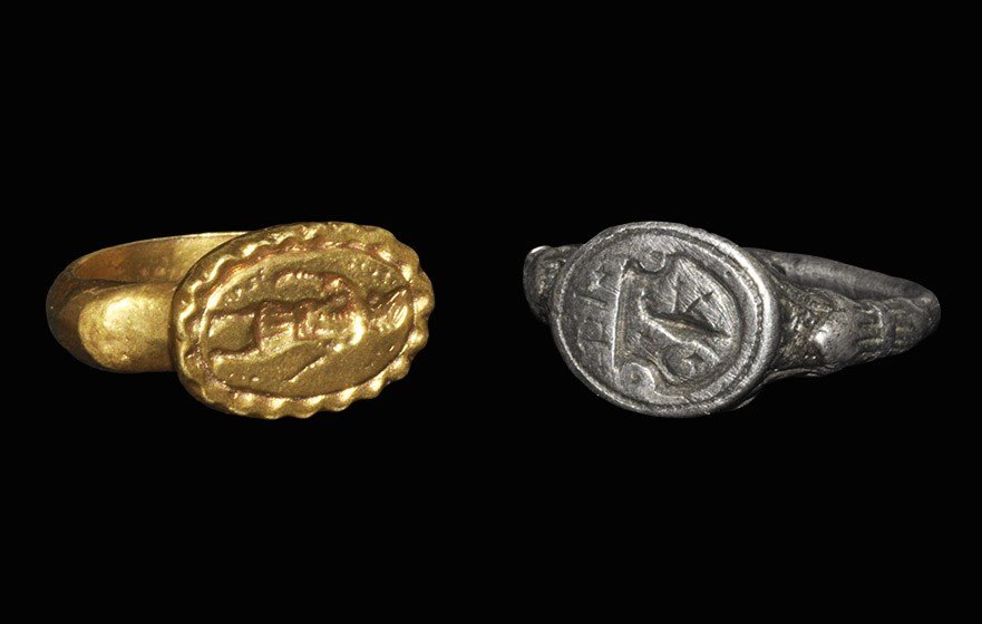 Post Medieval Silver and Copper Seal Matrix Ring Group: 18th century AD and later. A mixed group of two finger rings comprising: a silver seal matrix ring with foliage to the shoulders, elliptical bezel with intaglio design of a heater shield with bird, cr