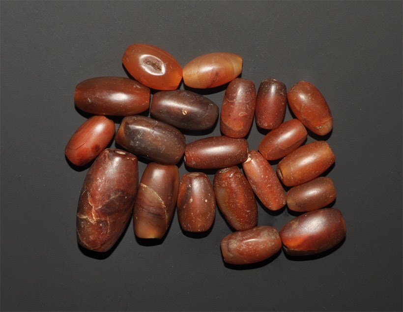 Cambodian Carnelian Bead Group: A mixed group of undated archaistic carved Pema Raka carnelian beads, ovals and barrels 80 grams total, 15-33mm (1/2 - 1 1/4"). Property of a London collector, acquired early 1990s. [20, No Reserve]