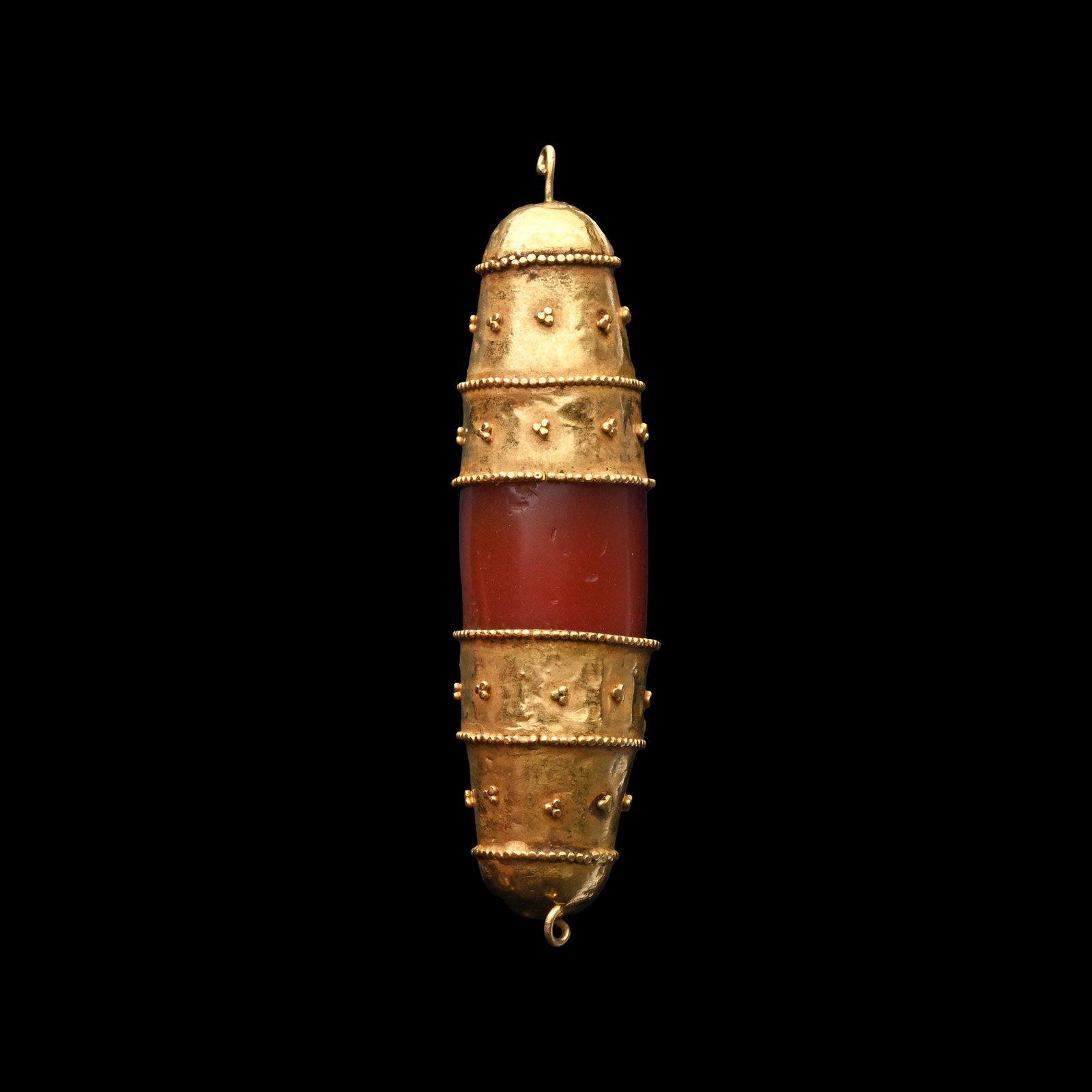 Greek Carnelian Bead with Gold End Caps: Hellenistic, 1st century B.C.-1st century A.D. Columnar bead with sheet-gold cap to each end, each with beaded circlets and applied granule clusters, domed end with loop; possibly assembled. Cf. a pai