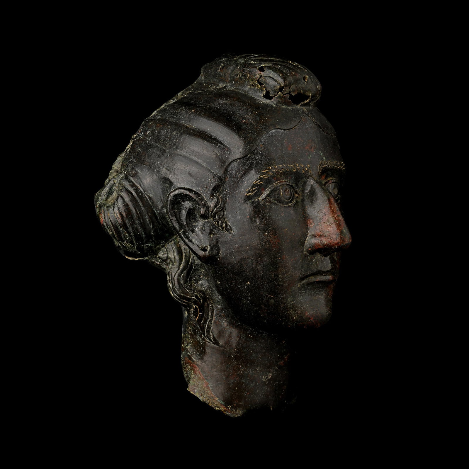 Life-Size Roman Bronze Head of an Empress: Mid-3rd century A.D. A member of the Imperial family, possibly an empress, depicted with an elaborate coiffure, the hair at the back of the head parted in the middle and the two strands folded over ea