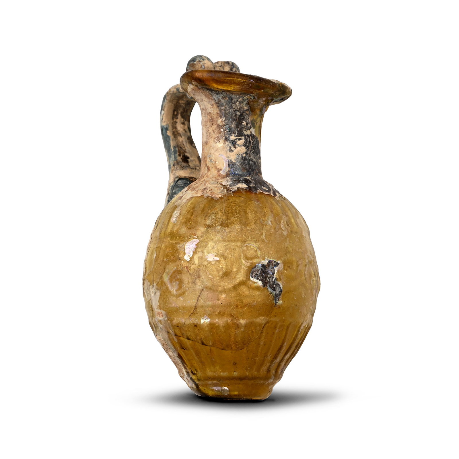 Roman Sidonian Mould Blown Glass Juglet: 3rd-4th century A.D. With a broad mouth, applied D-section handle and flattened foot, integral bands of vertical corrugation and S-scrolls to the equator. Cf. Antonaras, A., Ancient Glass in the J.Pau