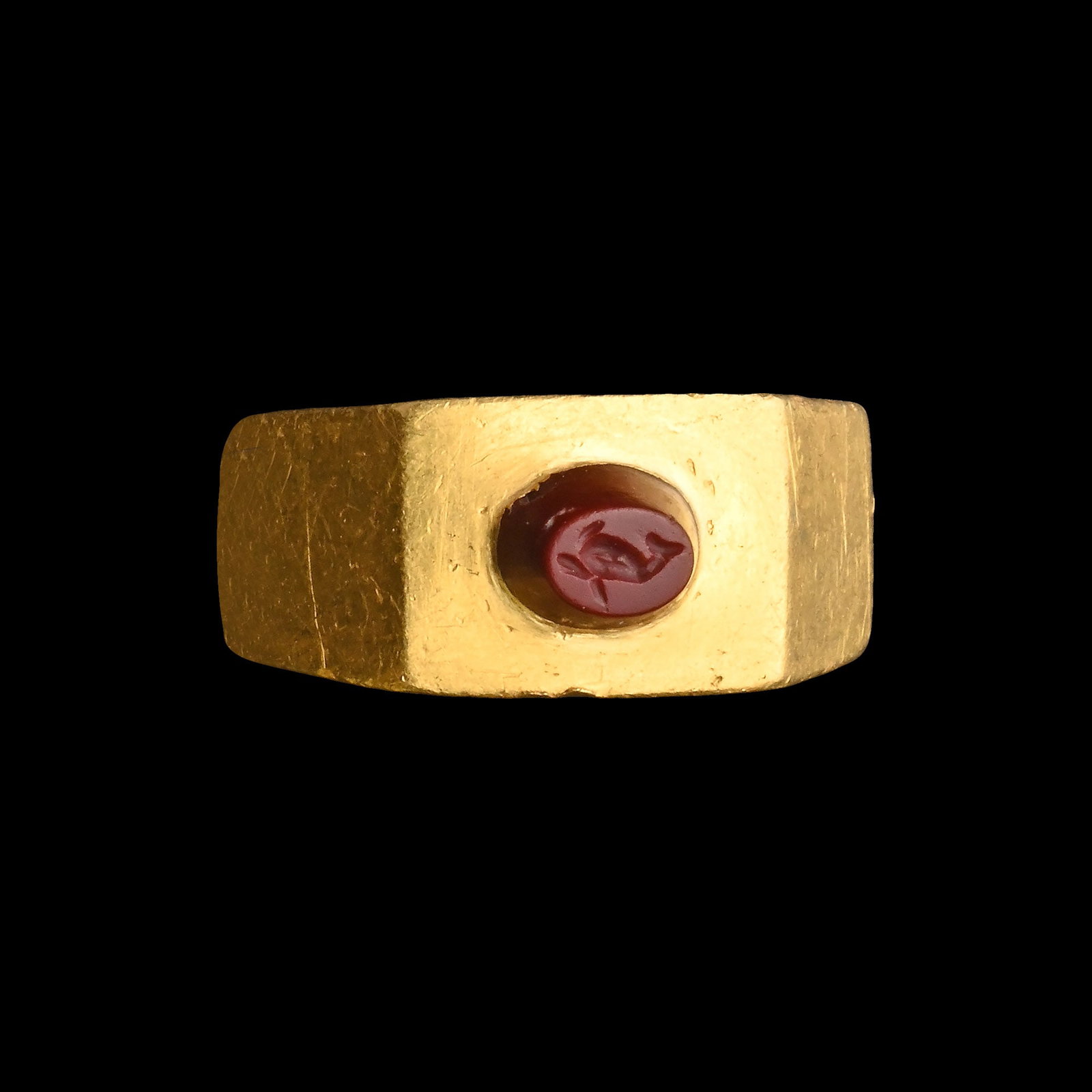 Roman Gold Ring with Jasper Gemstone with Dolphin: 2nd-3rd century A.D. Facetted rectangular-section hoop with square bezel set with a tall oval intaglio engraved with a dolphin. Cf. Ruseva-Slokoska, L., Roman Jewellery, Sofia, 1991, item 188, for typ