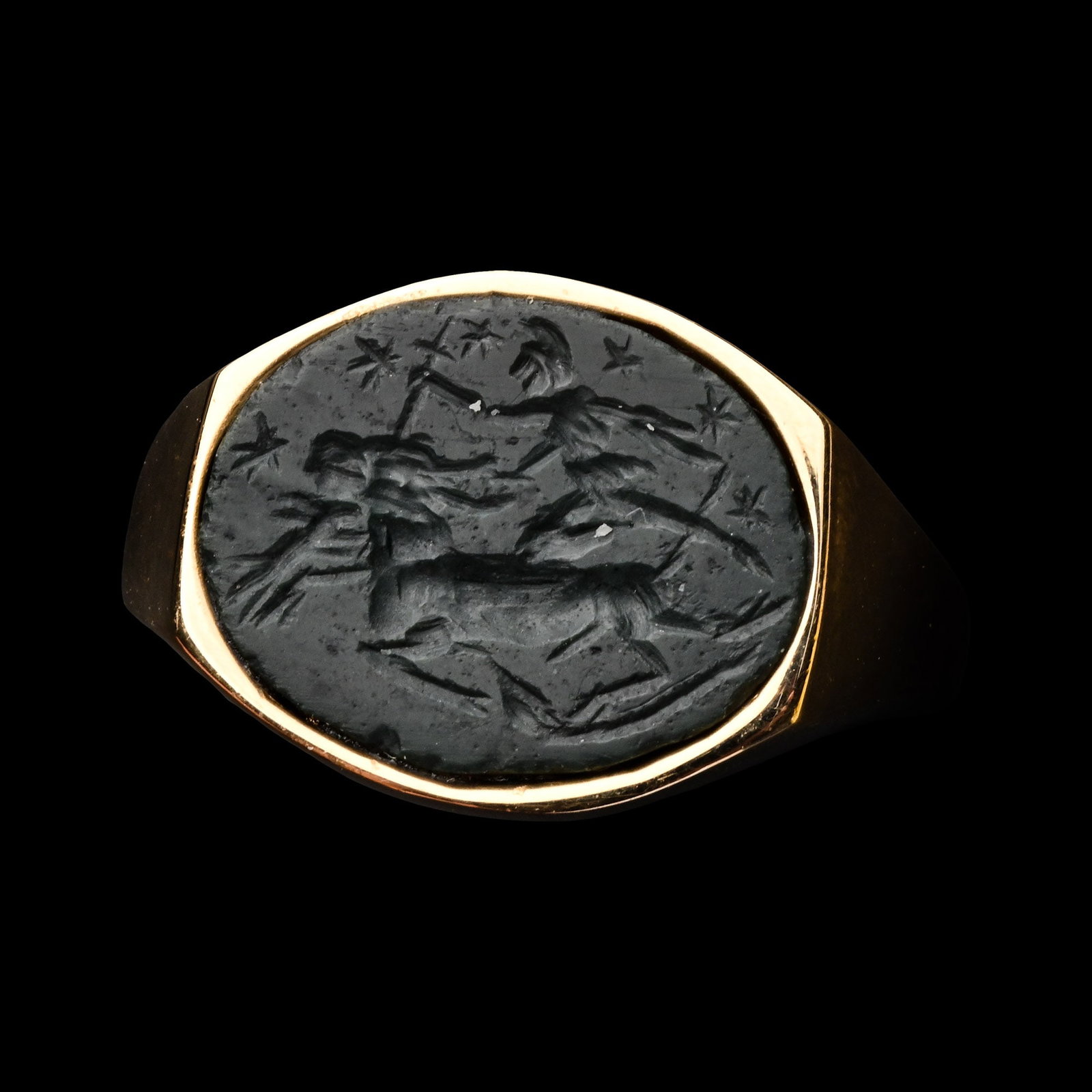 Roman Jasper Gemstone with Mithraic Tauroctony in Gold Ring: 3rd century A.D. An oval intaglio depicting Mithras, a snake and a dog killing a bull, six stars on the field; set in a later gold ring; supplied with a museum-quality impression. Cf. similar gemstone