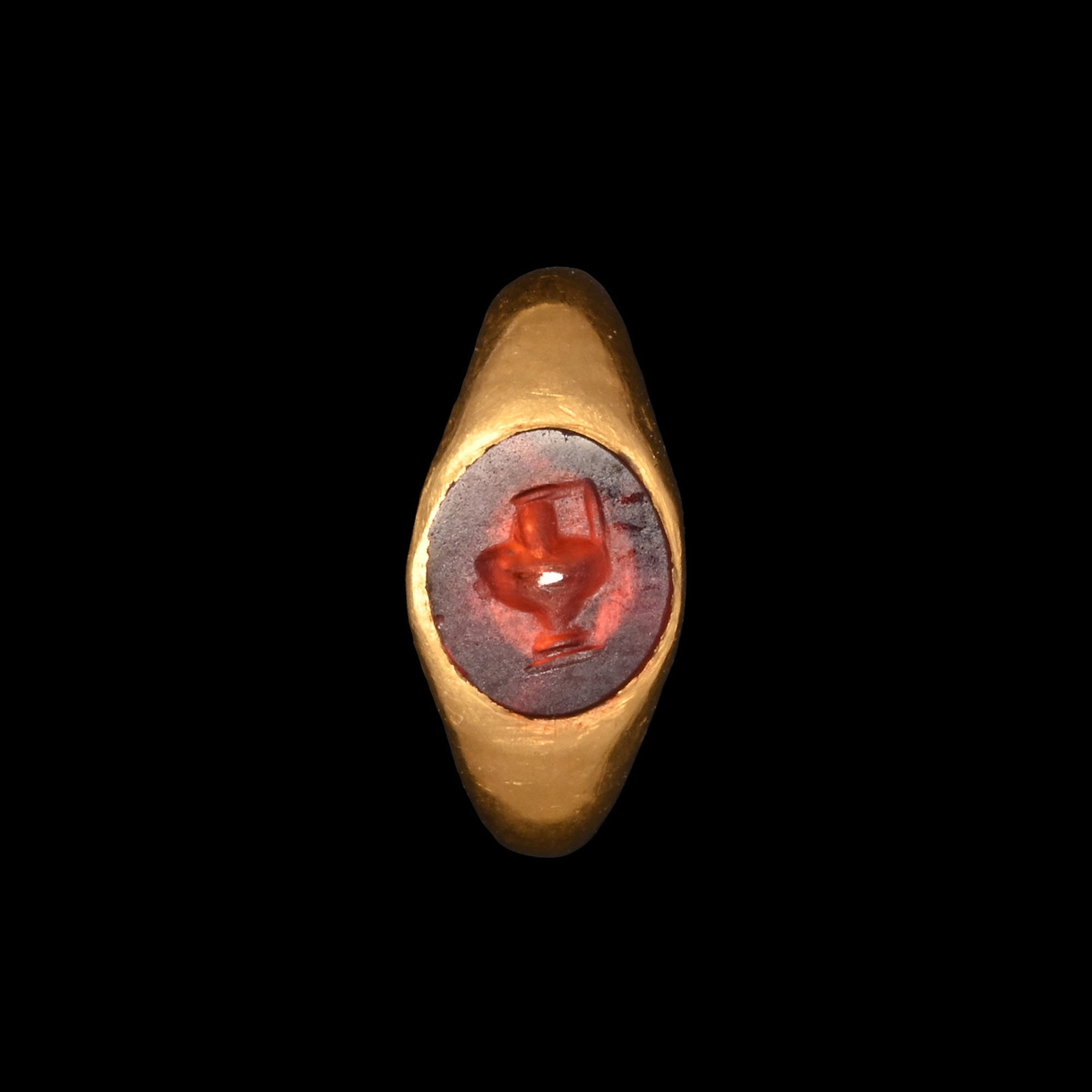 Roman Gold Child's Ring with Garnet Pitcher Gemstone: 1st century A.D. Solid ring inset with an intaglio of a guttus (pitcher) with socle foot and handle; supplied with a museum-quality impression. 0.87 grams, 9.77 mm overall, 7.20 mm internal diameter (