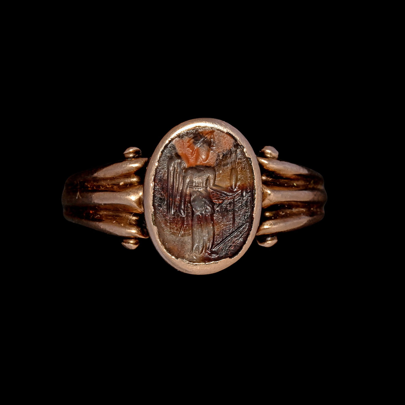 Roman Agate Gemstone of Syncretistic Fortuna in Gold Ring: 2nd-3rd century A.D. Intaglio of syncretistic Fortuna, winged like Victory and helmeted like Minerva in a long robe holding a rudder with an ear of corn and poppy; set into an antique gold ring; suppl