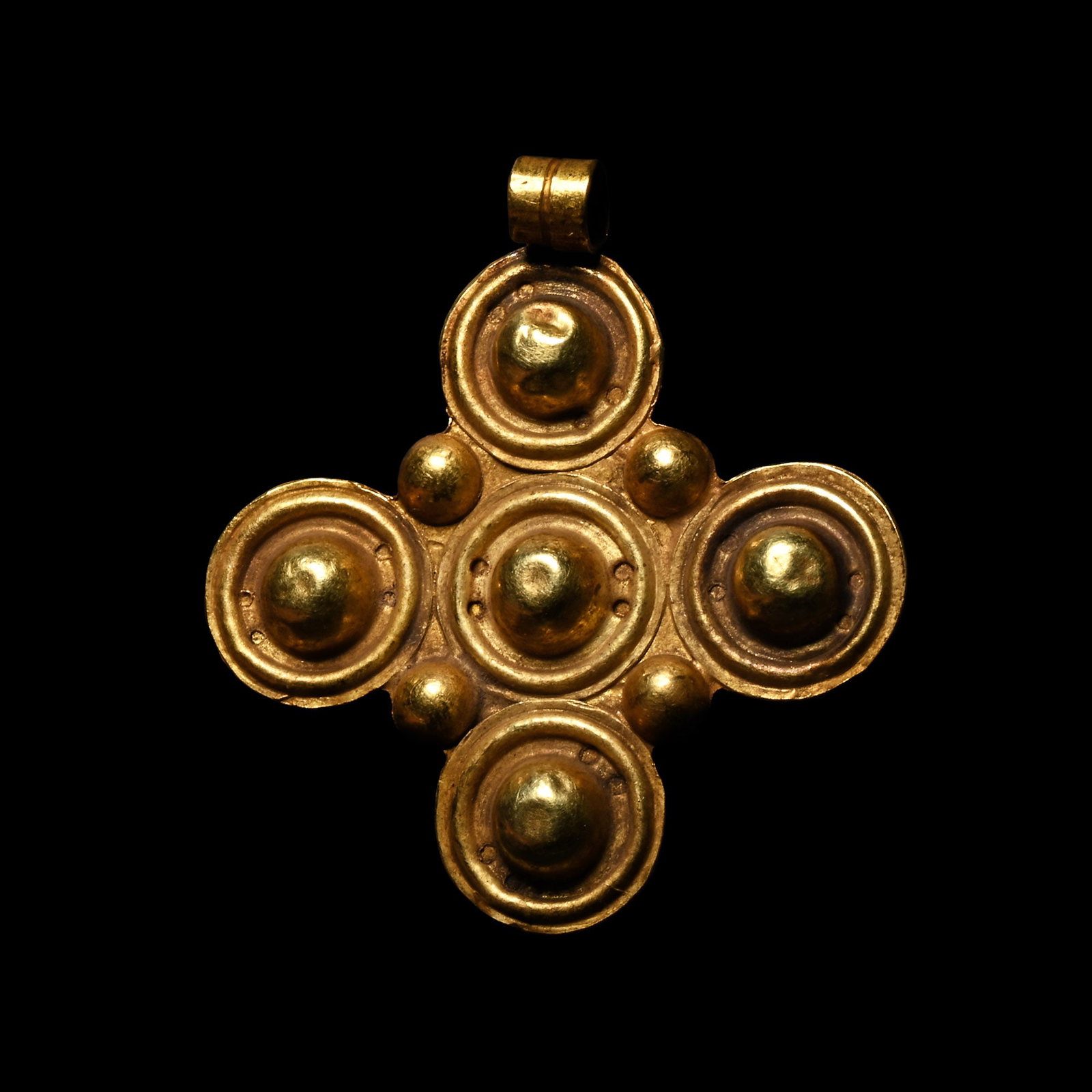 Byzantine Gold Cross Pendant with Bosses: Circa 6th-8th century A.D. Formed of five hemispherical bosses, likely representing the five wounds of Christ, with a small raised boss at each junction; applied suspension loop. 3.41 grams, 35 mm (1 