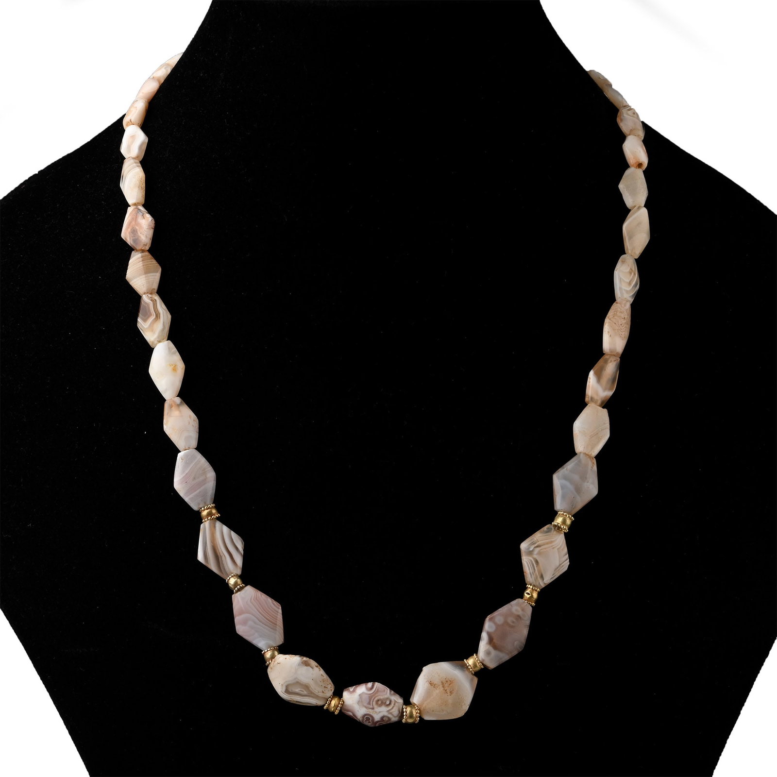 Western Asiatic Banded Agate and Gold Bead Necklace: 1st millennium B.C. and later Restrung group of graduated fusiform lentoid-section beads and at the centre interstitial collars with granulated borders; modern clasp. 42 grams, 55.5 cm (21 7/8 in.). E
