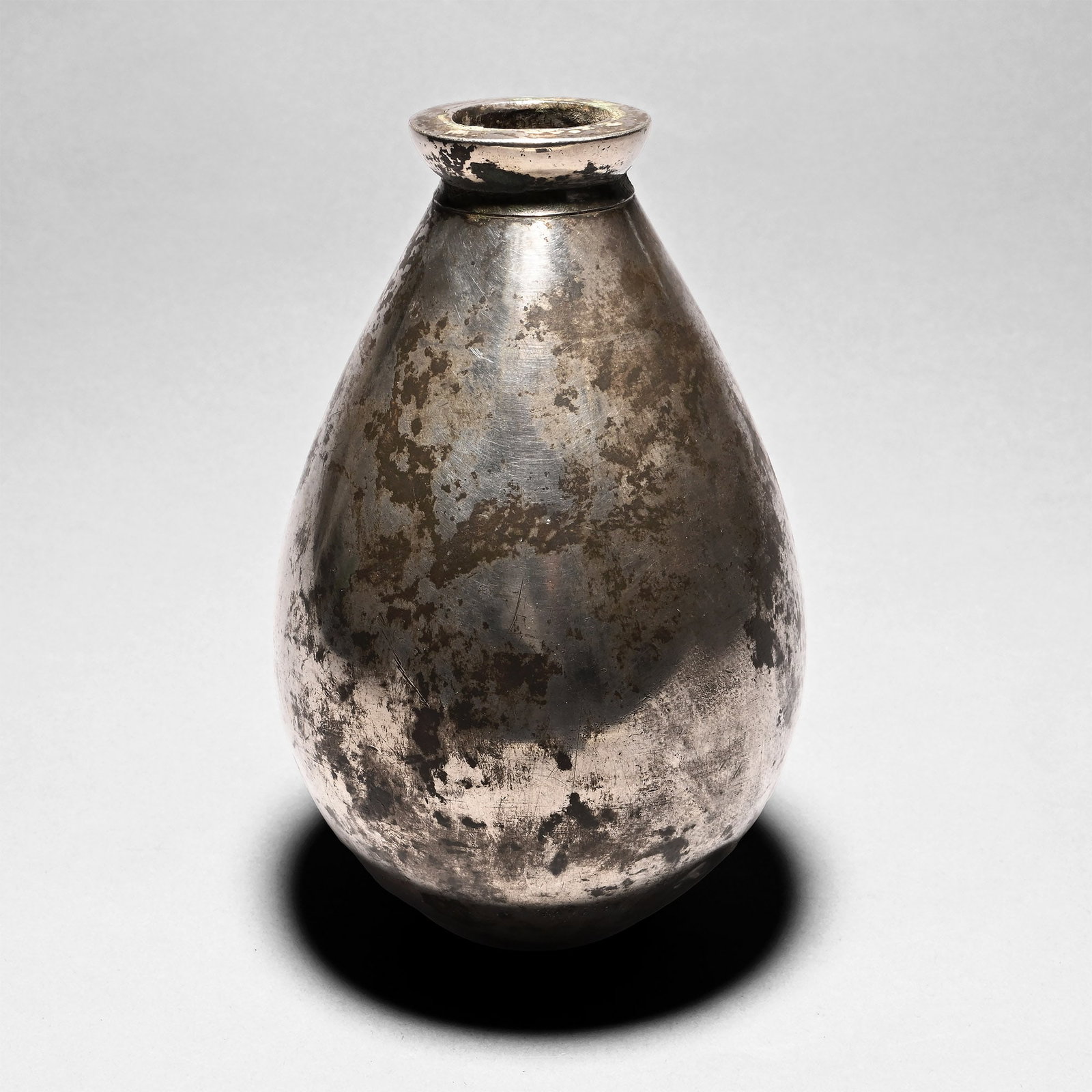 Large Sasanian Silver Bulb-Shaped Vessel: 5th-6th century A.D. Ovoid in profile with a short neck and a flat rim, pierced at the bottom; minor dents to the surface. See 'Anahita vessel' at the Cleveland Museum of Art, for the shape. 485 grams