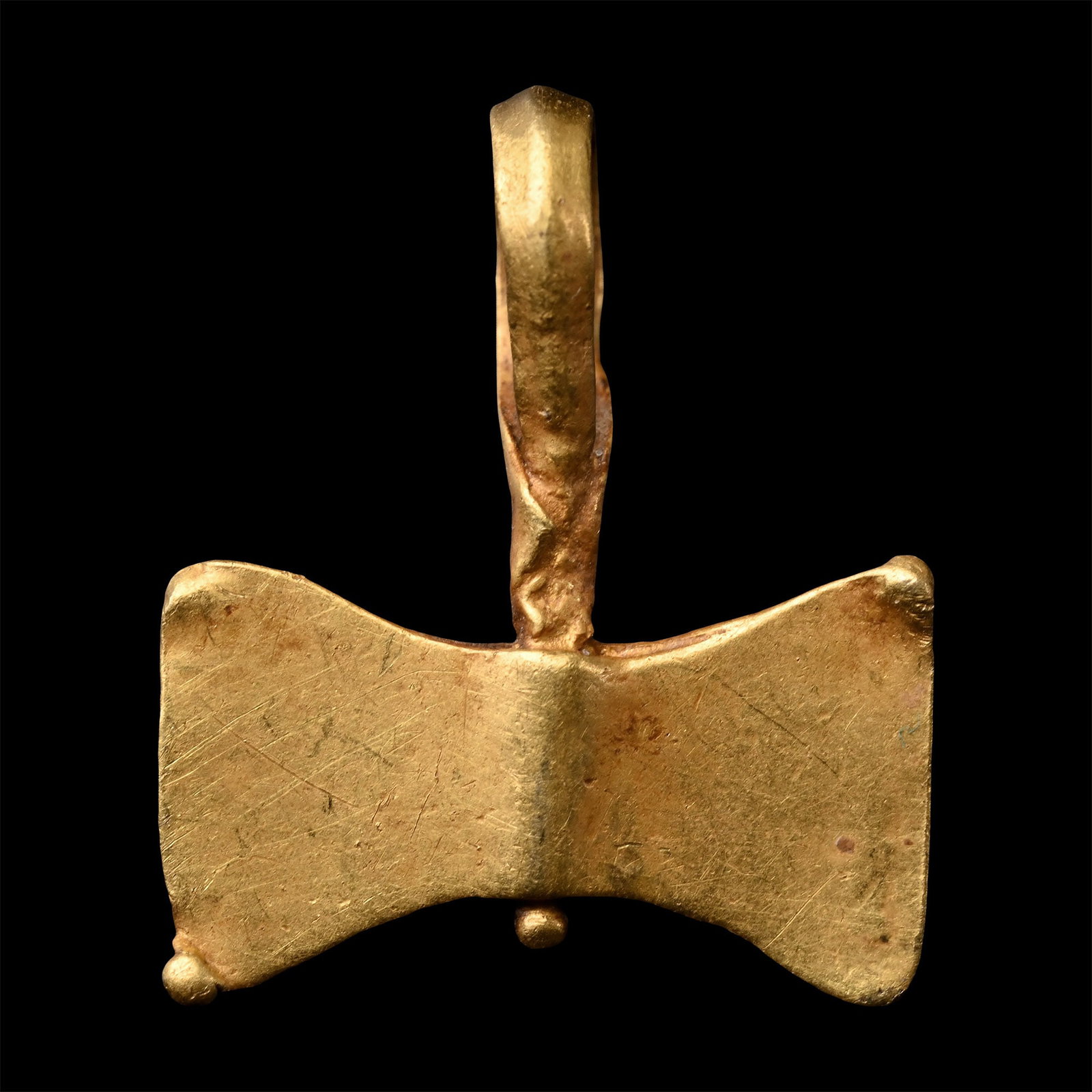 Migration Period Gold Double Axehead Pendant: Circa 6th-8th century A.D. Formed as a miniature twibil with loop handle and granule to each corner. 0.64 grams, 13 mm (1/2 in.). Ex German art market, 2000s. Acquired from an EU collector living in L