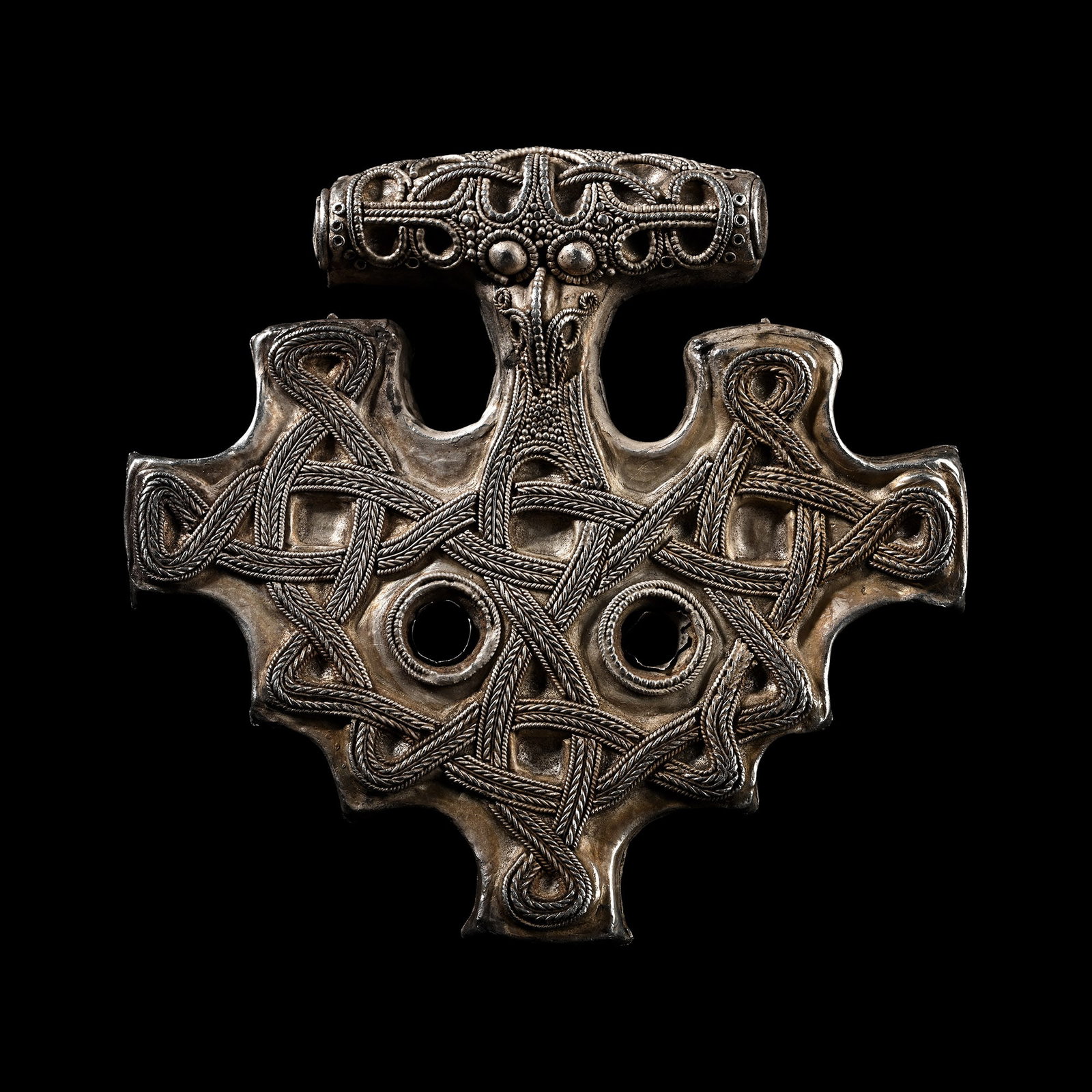 Very Large Scandinavian Viking Silver Tau Cross Pendant: 10th-12th century A.D. Hollow-formed type with barrel-shaped suspension bar, narrow neck, trefoil plaque with two lateral piercings; applied filigree knotwork to the plaque and suspension bar, domed '