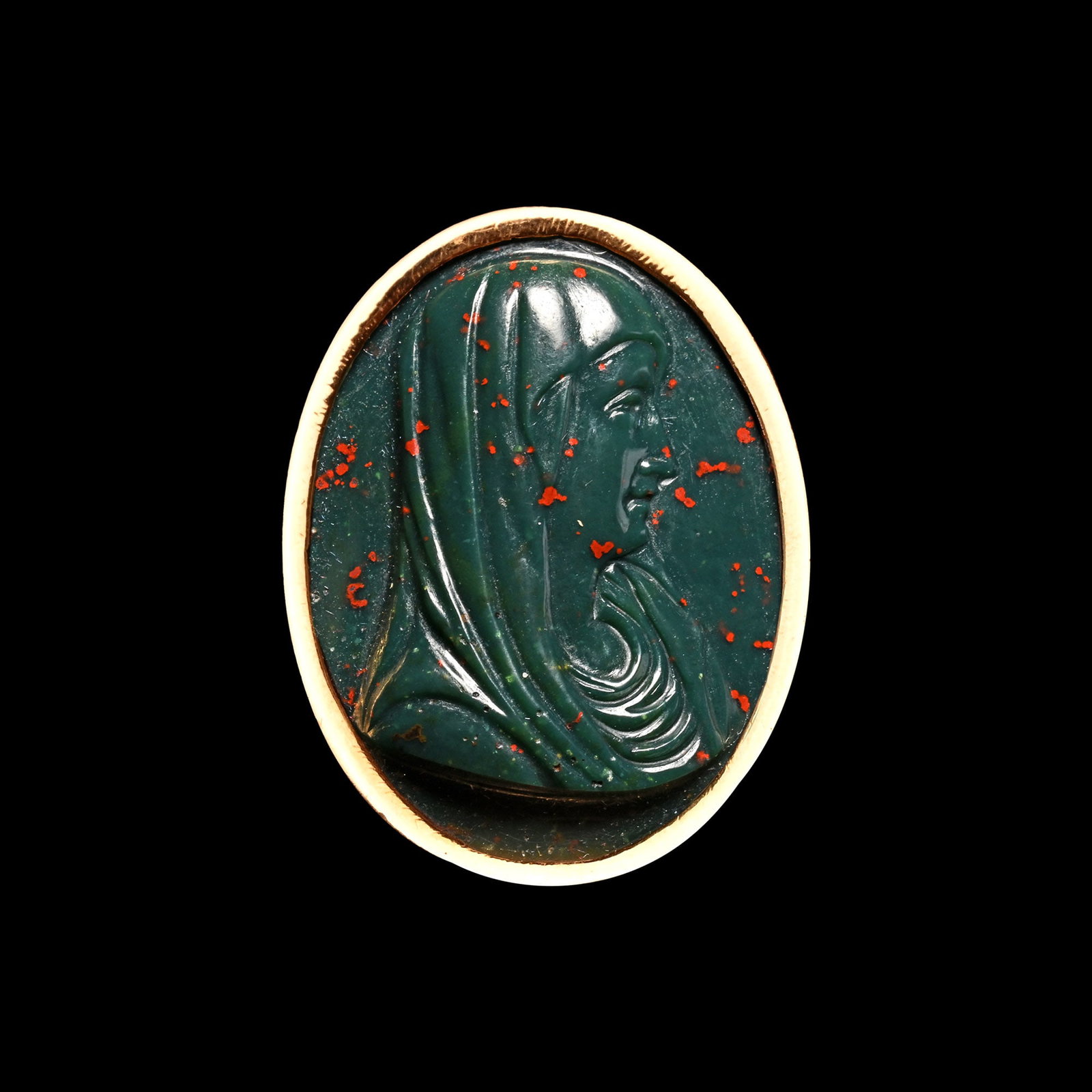 Late Renaissance Double-Sided Heliotrope Cameo of Christ and the Virgin in Gold Ring: Italy, 17th century A.D. Comprising a dark green oval cameo with bright red flecks, on the upper side, a veiled head of Mary with a solemn expression, the underside featuring a classical depiction of 