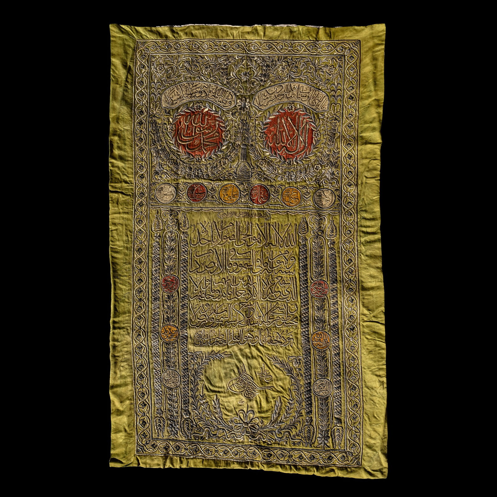 Metal-Thread Embroidered Silk Panel with the Tughra of Sultan Mahmud II: Ottoman Empire, circa 1808-1839 A.D. Rectangular in plan, the lime green silk field with two large roundels of red silk tied by a tassel in the rococo style, signature of Sultan Mahmud II contained wi