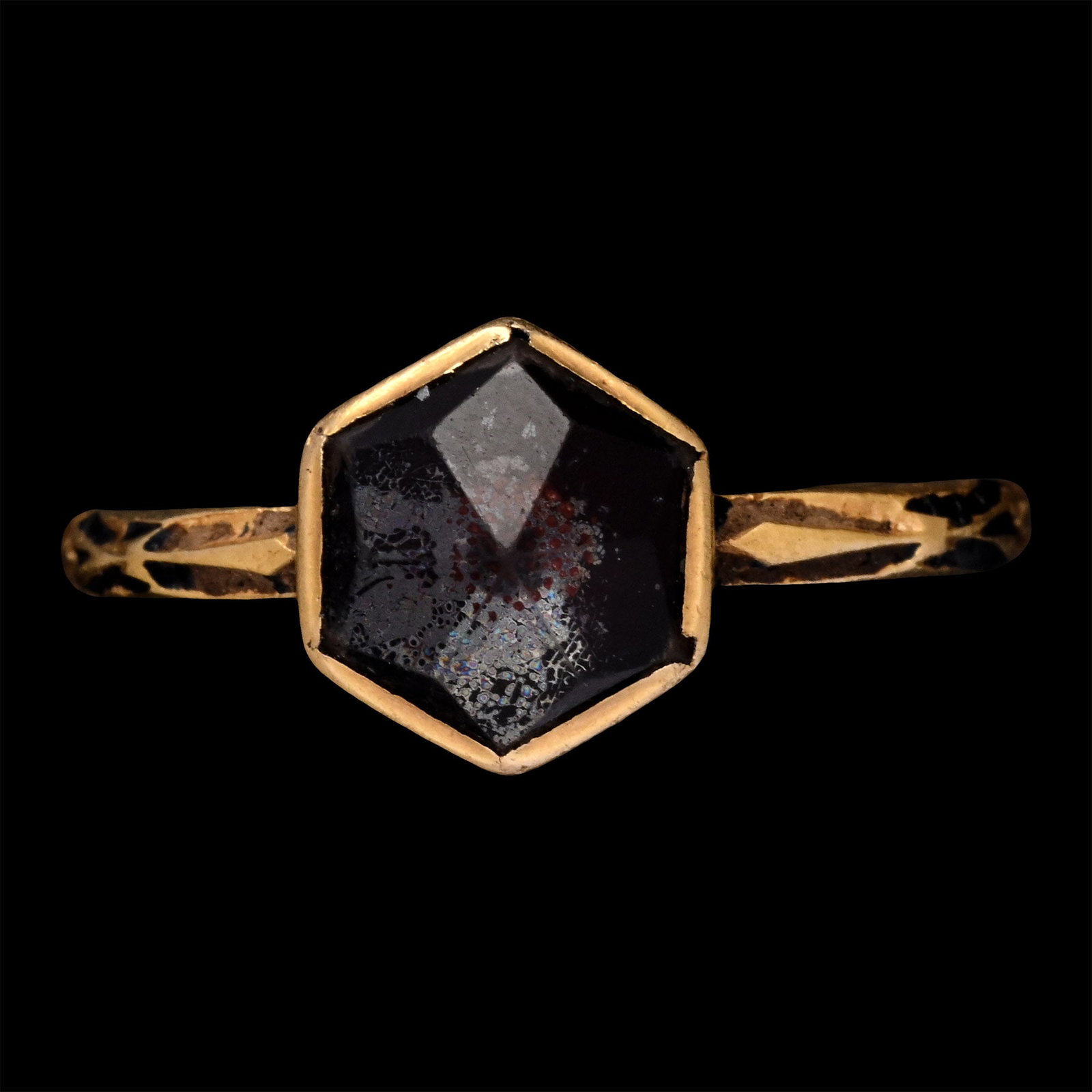 Renaissance Gold Enamelled Ring with Rock Crystal: 16th century A.D. Featuring a slender hoop with black-enamelled shoulders, a hexagonal collet setting with point-cut quartz with foil backing, and black-enamelled decoration beneath the setting. 2.91 
