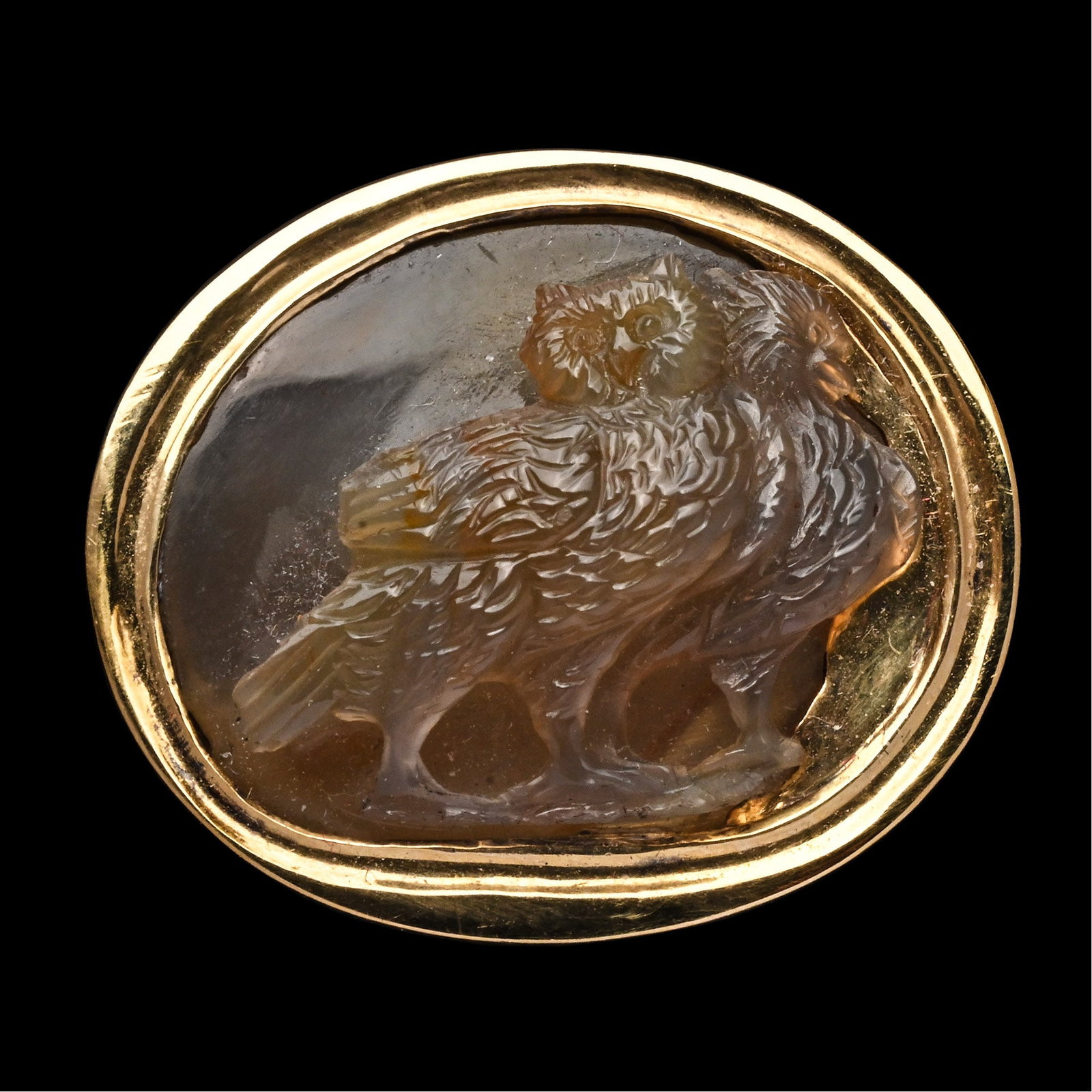 Renaissance Agate Cameo of Two Owls in Gold Ring: Italy, 17th century A.D. Comprising a D-section hoop expanding towards the open-backed setting set with a large brown agate intaglio modelled as two conjoined standing owls, the one at the front facin