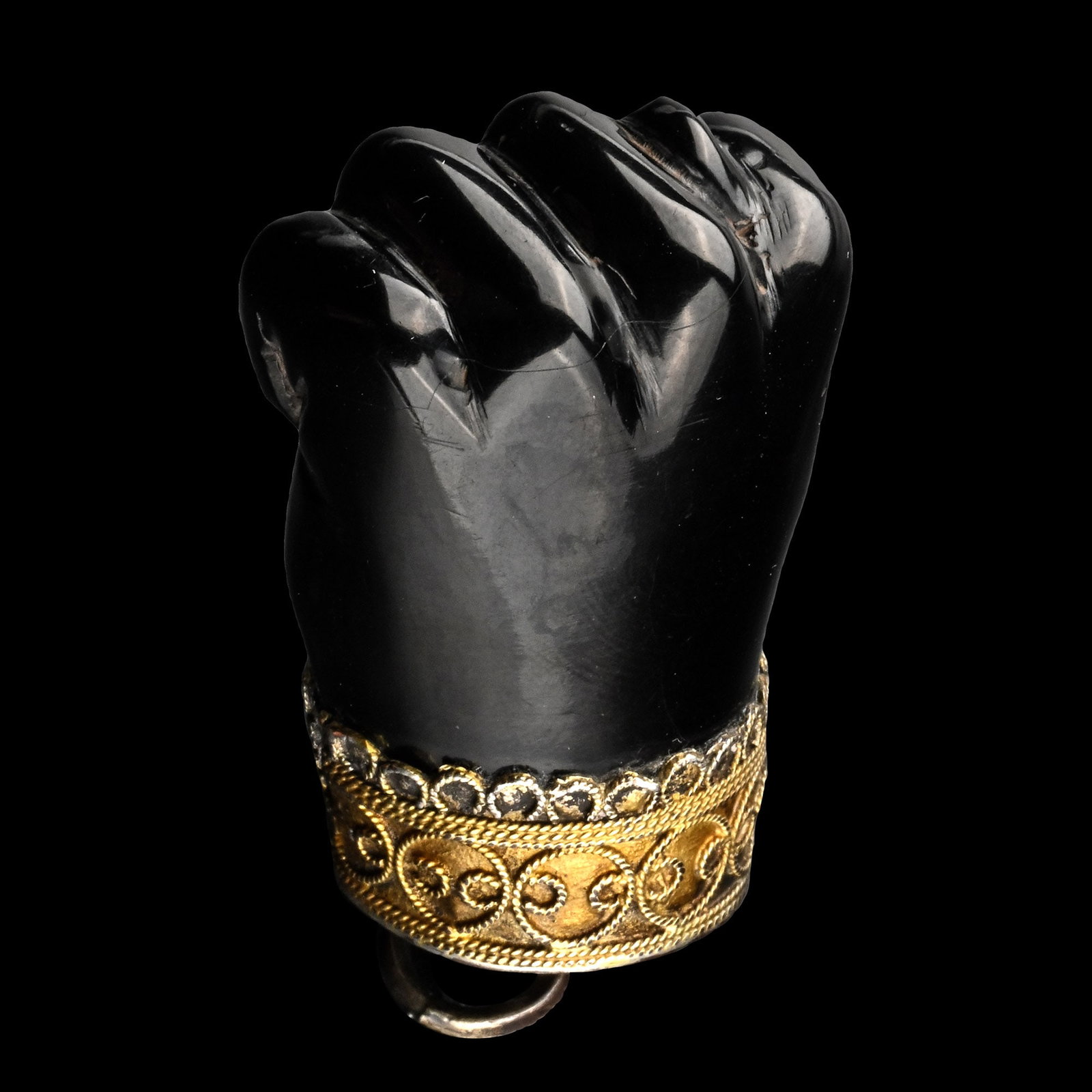Silver-Gilt Mounted Jet 'Figa' Amulet: Spain, 17th century A.D. Formed as a hand showing figa gesture, silver mount with applied twisted wires; attachment loop and ring to the top. 19.6 grams, 56 mm (2 1/4 in.). Private collection, Europe.